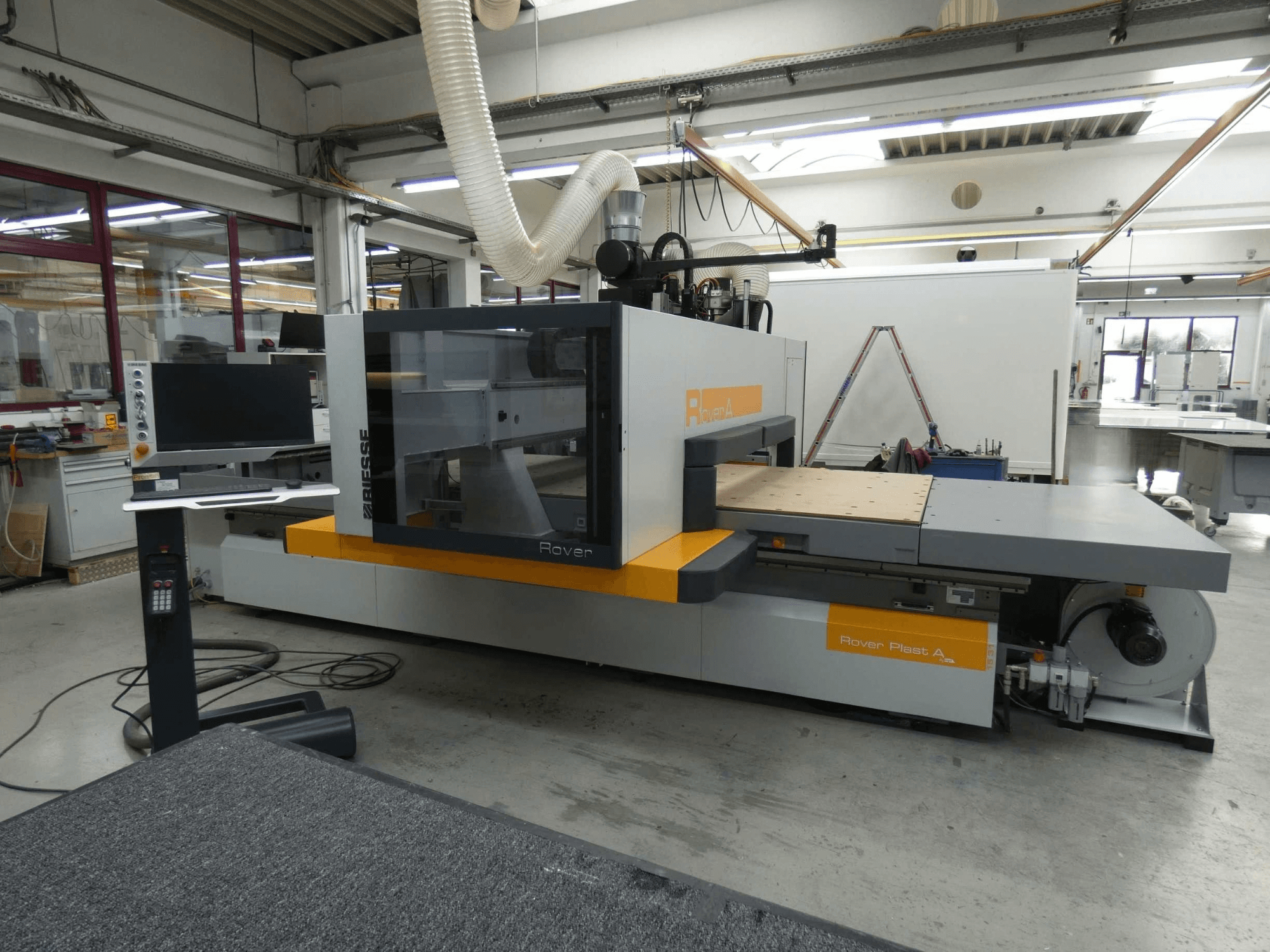 Pohled zepředu na CNC centrum pro obrábění dřeva BIESSE ROVER PLAST A FT 1224 s viditelným monitorem a ovládacím panelem.