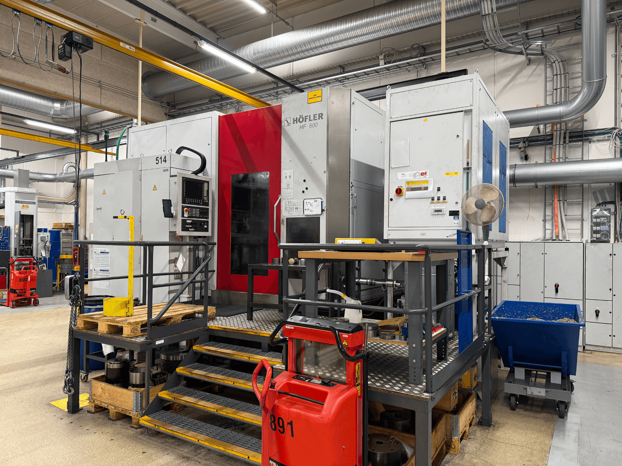Obráběcí stroj HOFLER HF 600, boční pohled, zobrazující ovládací panel, žlutou bezpečnostní zábranu a okolní prostředí dílny.