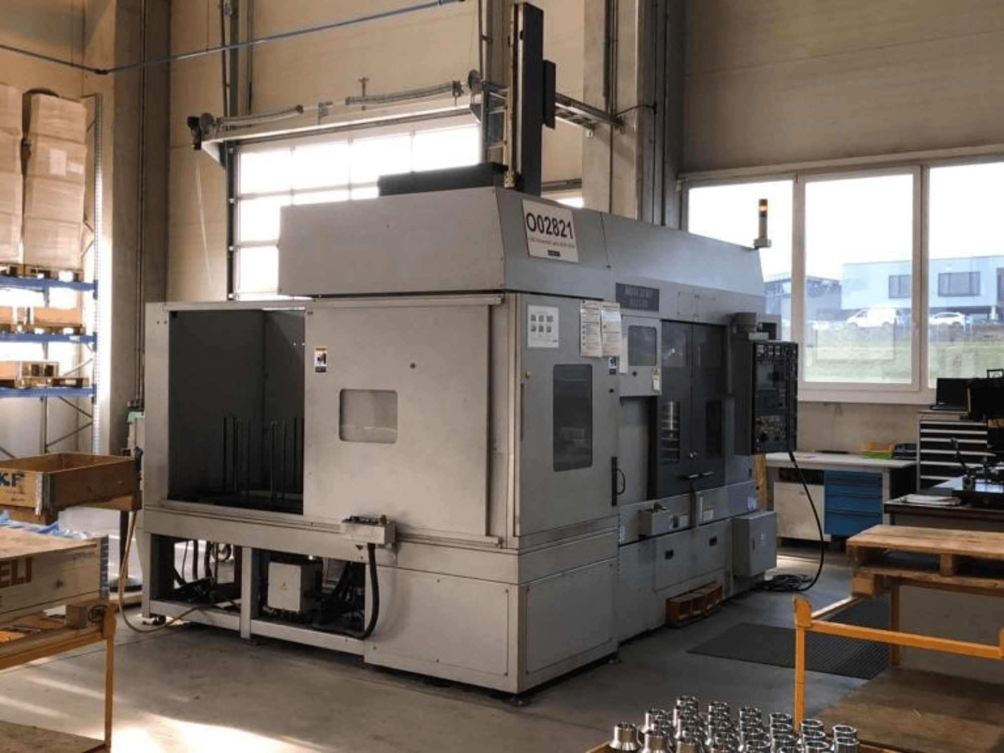 Vícevřetenový soustruh MORI SEIKI RL2500 v dílně, pohled zepředu a výrobní prostor s nástroji.
