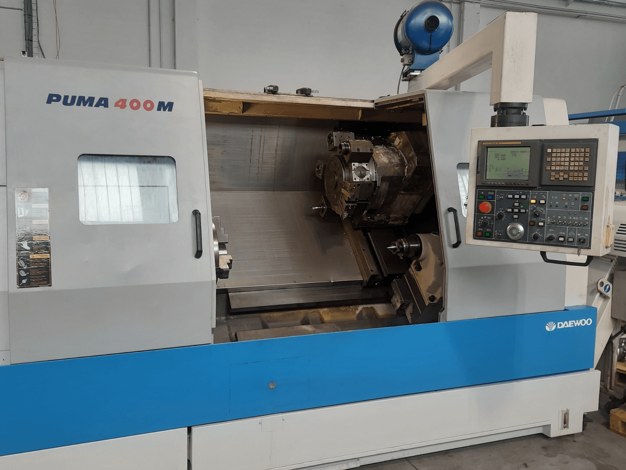Pohled zepředu na horizontální soustruh DAEWOO PUMA 400MB s viditelnými ovládacími prvky a řezacím nástrojem v pracovní komoře.