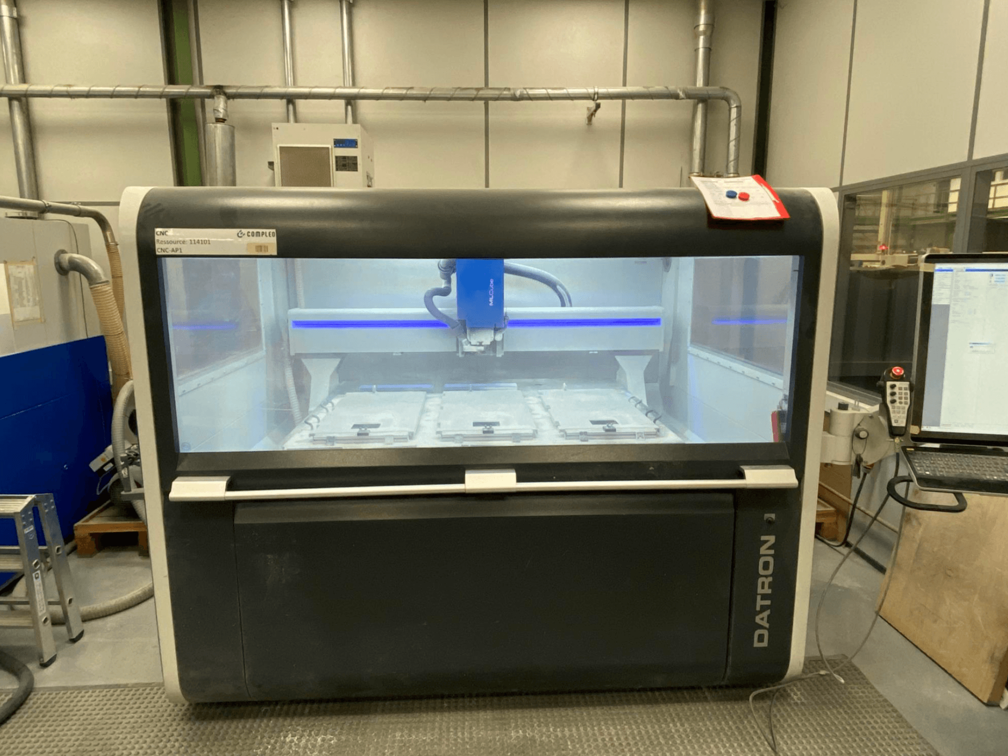 Vertikální obráběcí centrum Datron MLCube B, pohled zepředu, vnitřní prostor stroje a ovládací panel.