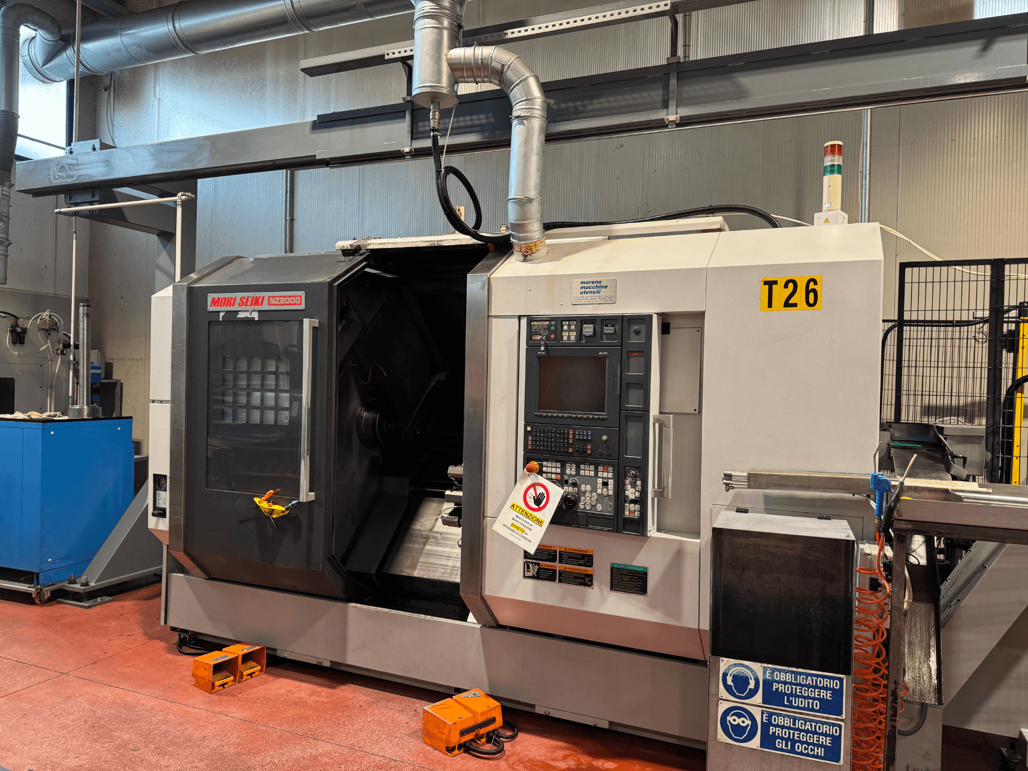 Soustružnické centrum MORI SEIKI NZ-2000/T2/Y2, pohled zepředu, s ovládacím panelem, bezpečnostním značením a průmyslovým nastavením.