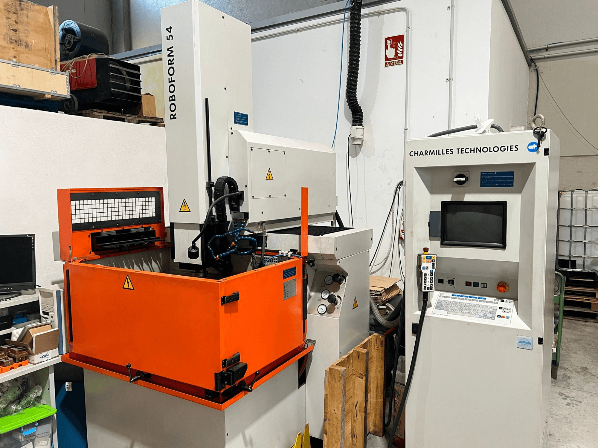 Hloubicí elektroerozivní stroj AgieCharmilles Roboform 54, pohled zepředu, s oranžovou pracovní nádrží a řídicí jednotkou.