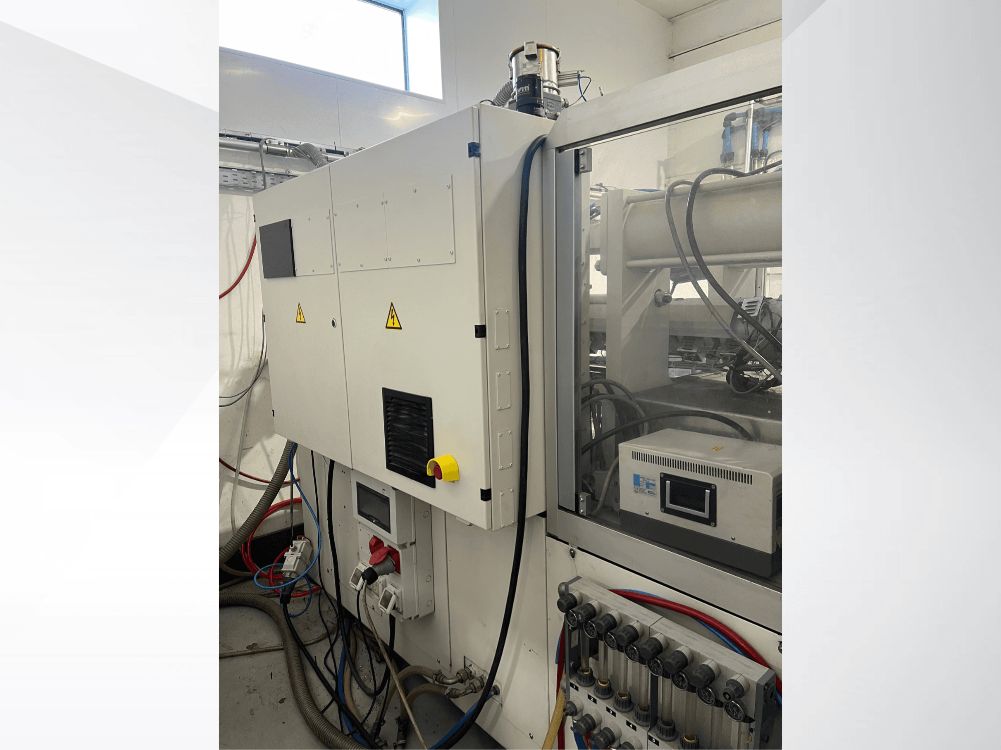 Hydraulický vstřikovací lis Krauss Maffei 125-520 C1, boční pohled znázorňující ovládací panel a hydraulické přípojky.