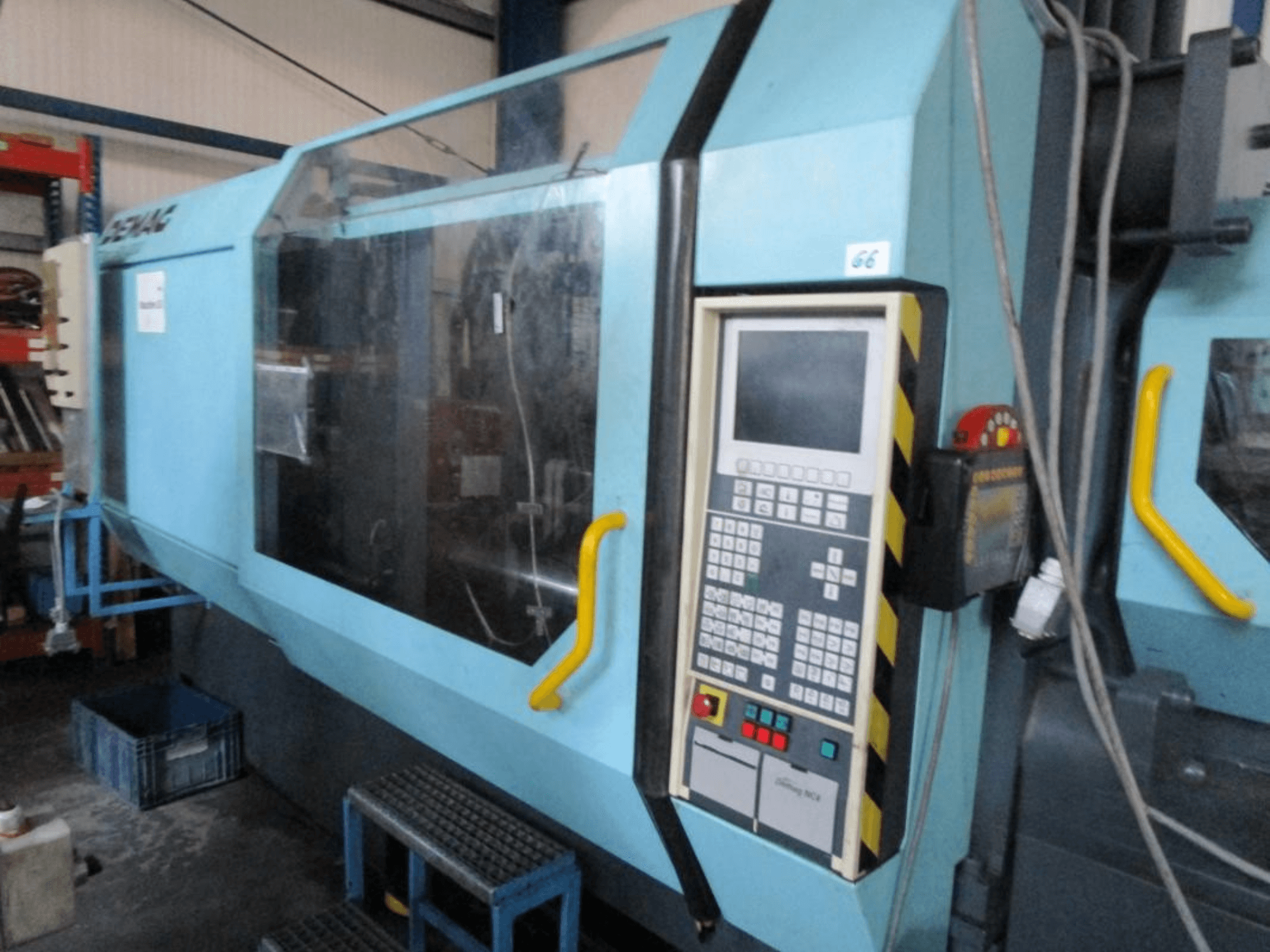 Hydraulický vstřikovací stroj Demag Erdotech 500-3300, pohled zepředu, s ovládacím panelem a průhledným bezpečnostním krytem.