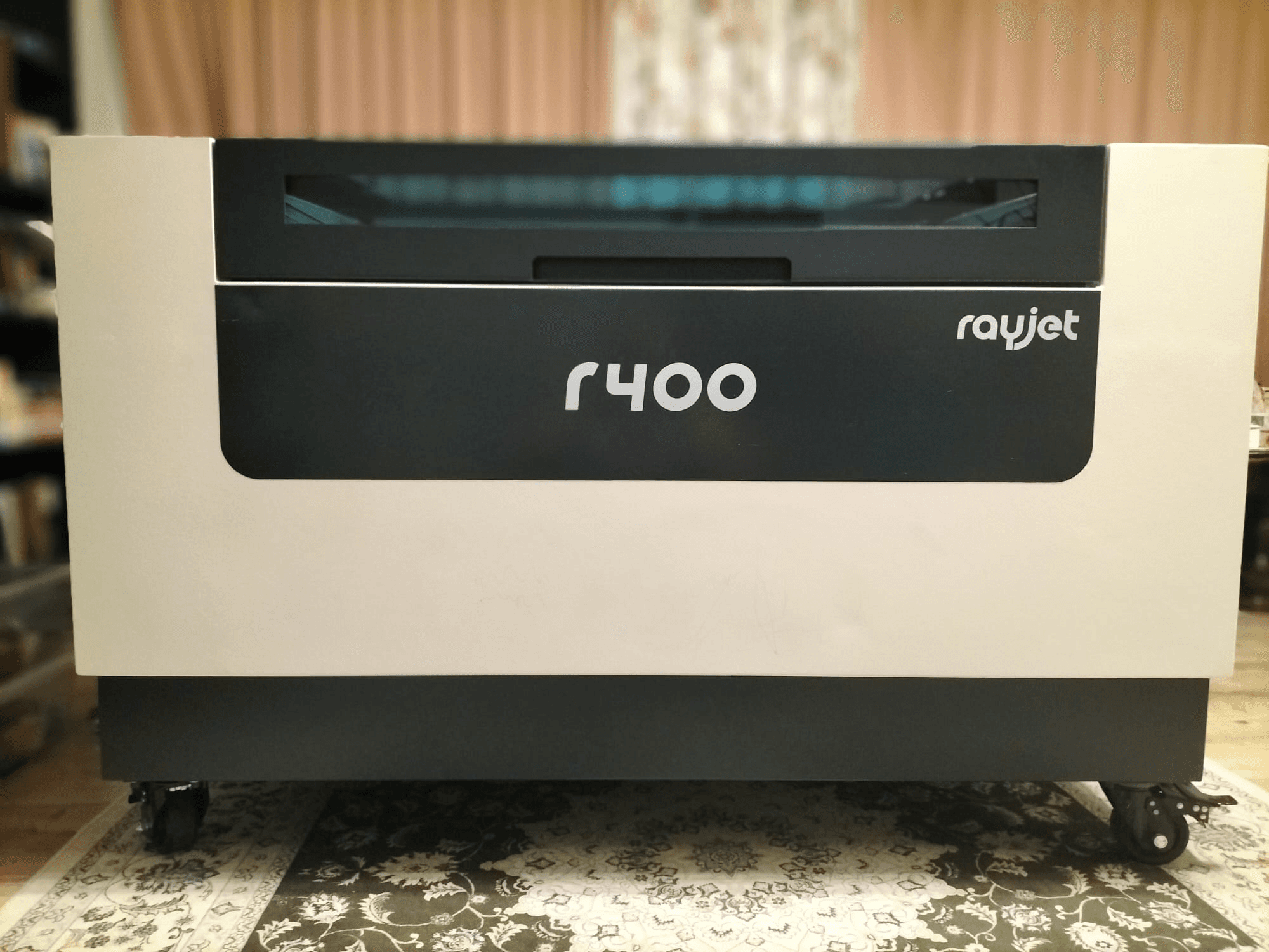 Pohled na laserový gravírovací stroj Trotec Rayjet R400 zepředu, který ukazuje jeho elegantní design a jasné označení.