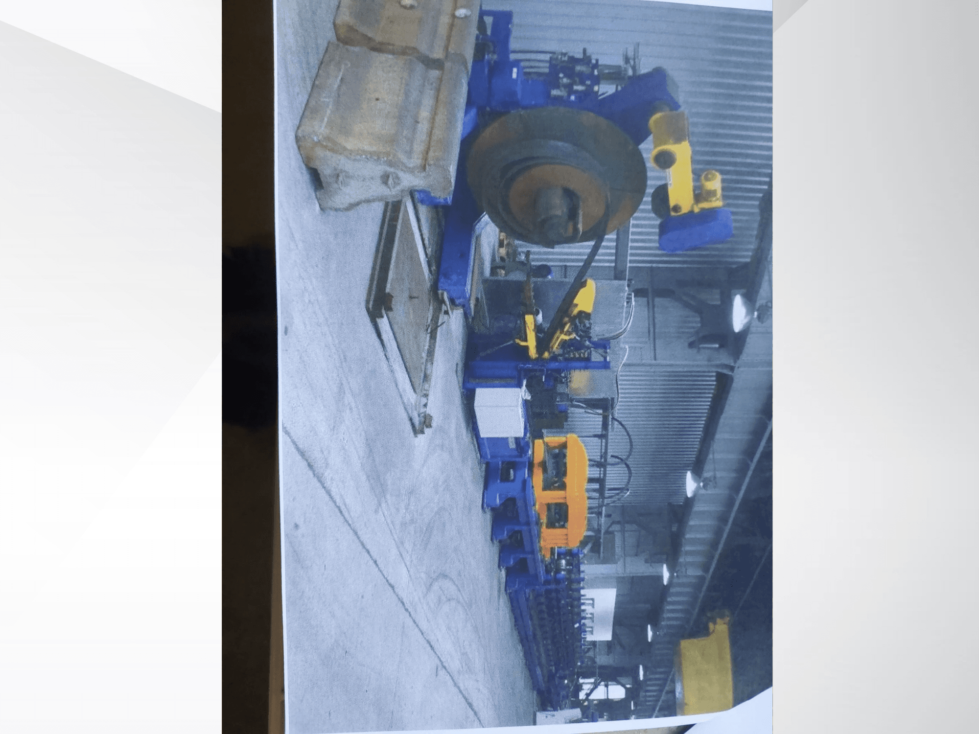 Ohýbačka profilů Müller Profilierung 3 v dílně, na které je patrná modrá konstrukce a žluté hydraulické součásti.