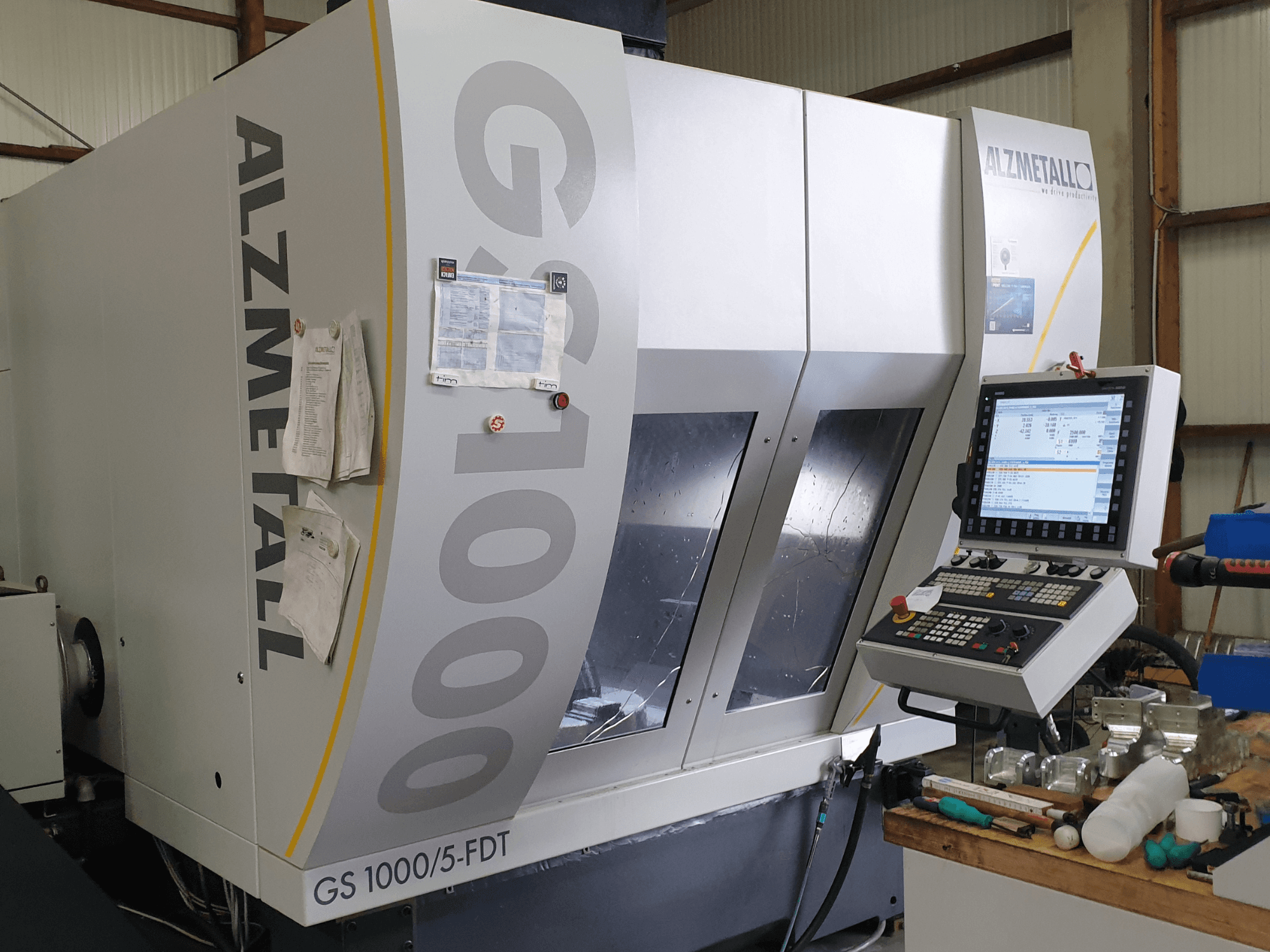 Vertikální obráběcí centrum Alzmetall GS 1000/5-FDT v čelním pohledu, na kterém je vidět ovládací panel a pracovní prostor.