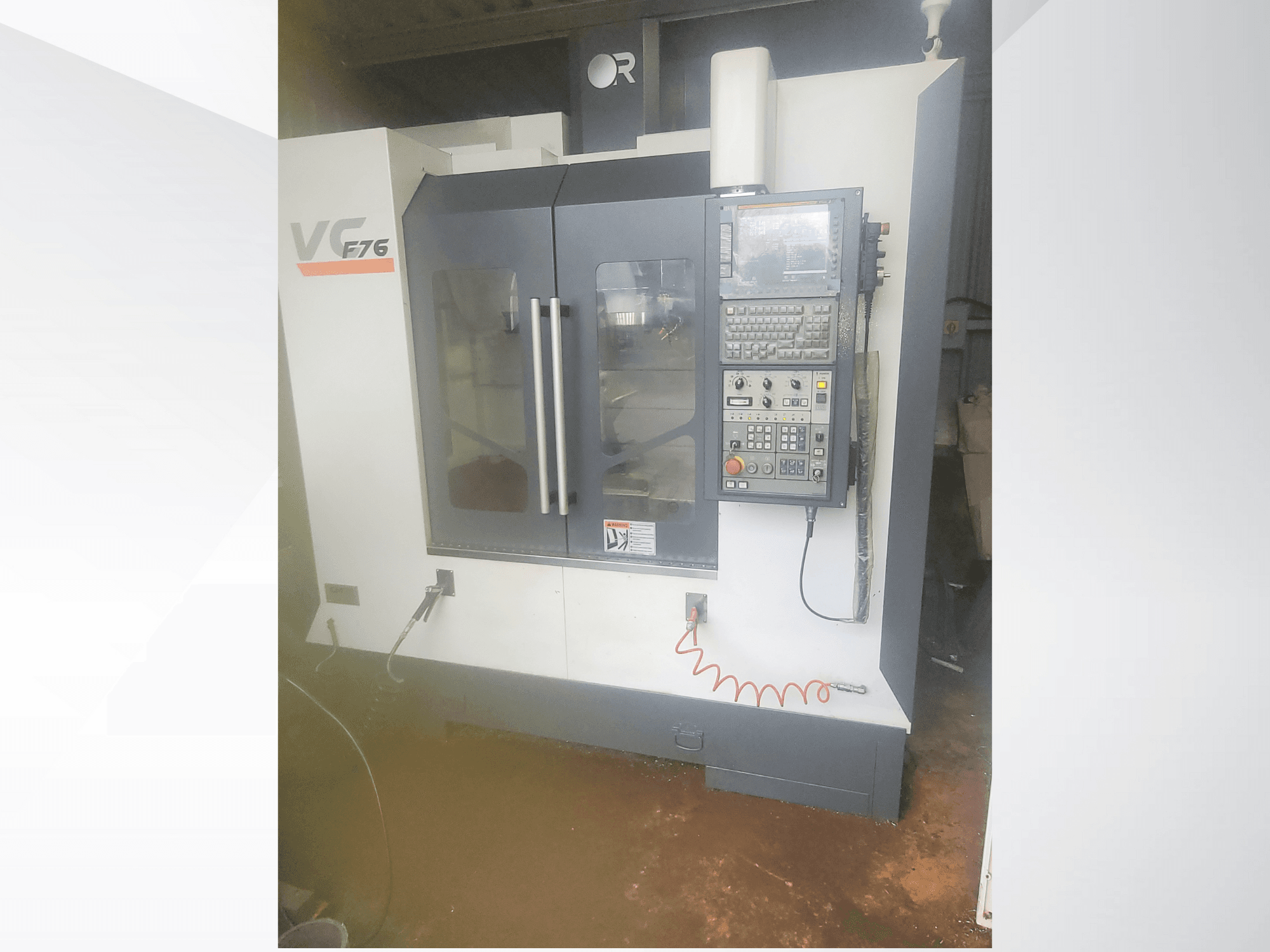 Vertikální obráběcí centrum, značka VC, model F76; čelní pohled ukazuje ovládací panel a skleněné dveře.