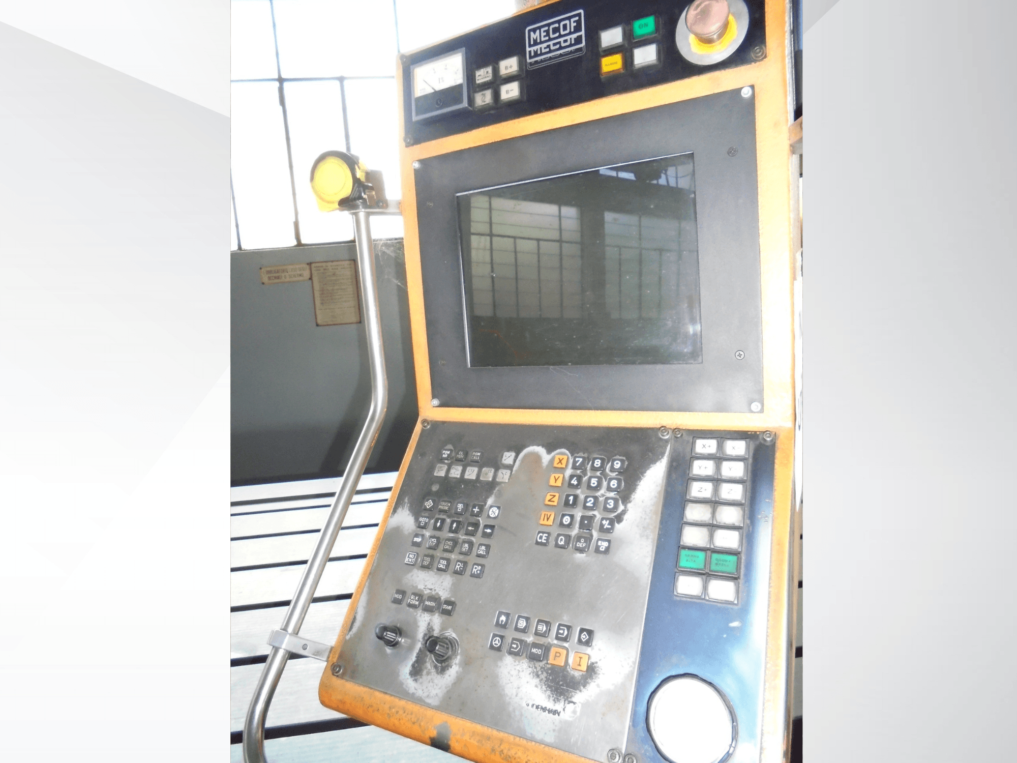 Ovládací panel Mecof s digitálním displejem, tlačítky a knoflíky; pohled zepředu ukazuje opotřebení ovládacích prvků.