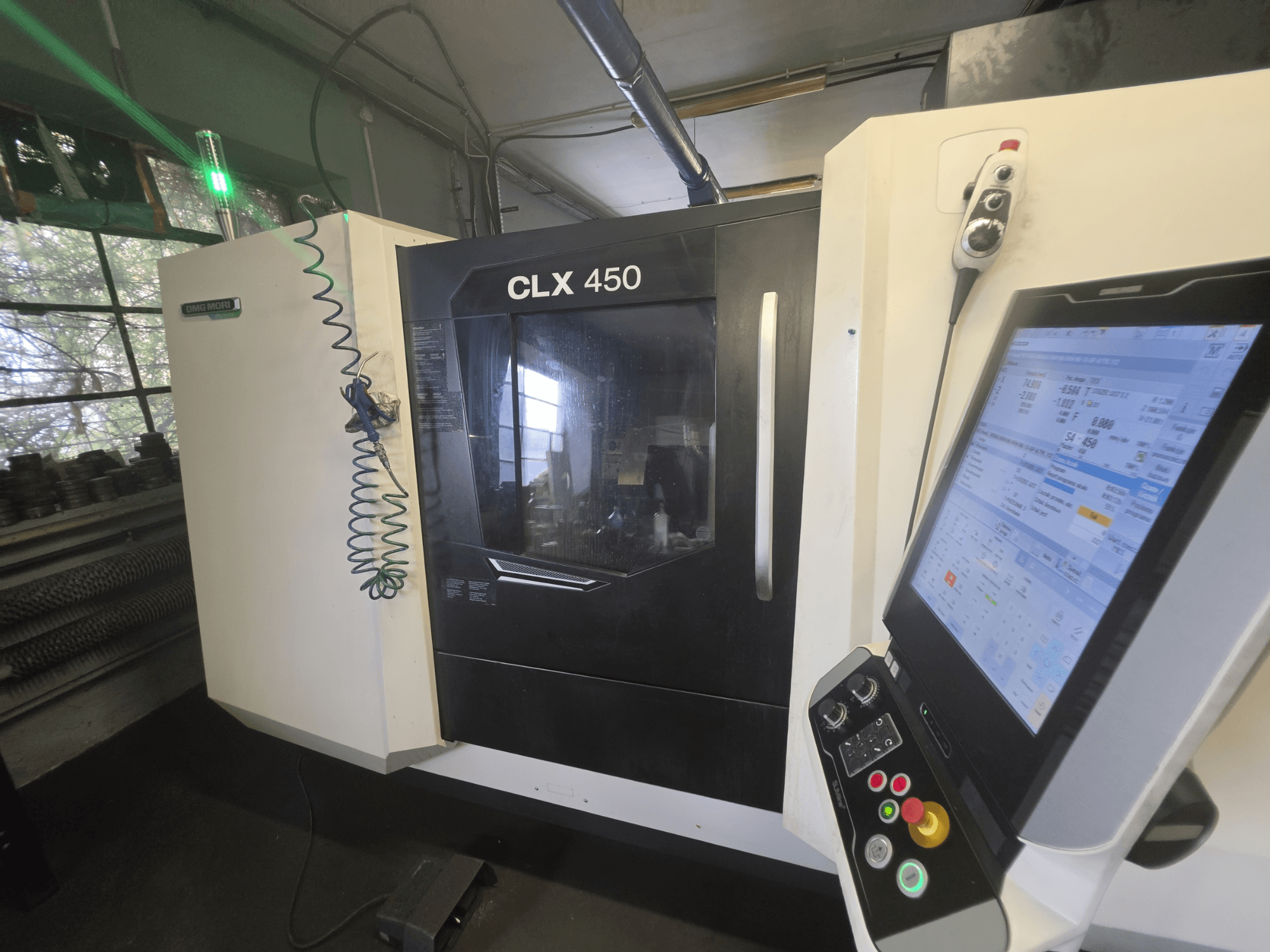 Horizontální soustruh DMG MORI CLX 450 V3, pohled zepředu s ovládacím panelem a monitorem zobrazujícím provozní údaje.