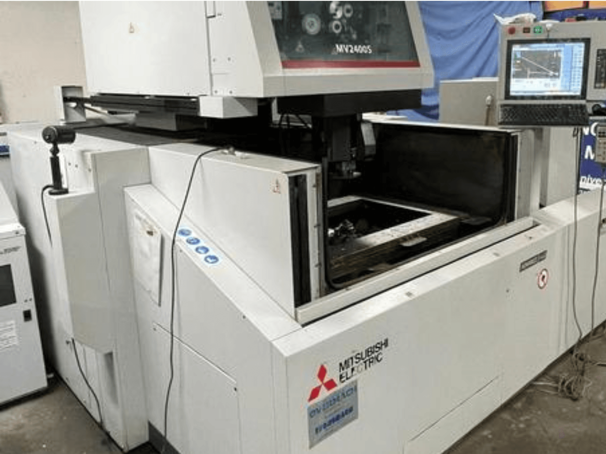Elektroerozivní drátový obráběcí stroj Mitsubishi Electric MV2400S, pohled zepředu, zobrazující ovládací panel a otevřený pracovní prostor.