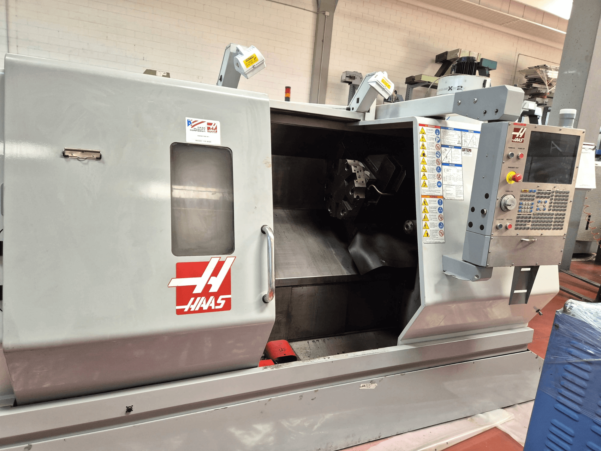 Horizontální soustruh Haas SL 30TBHE, pohled zepředu znázorňující ovládací prvky a otevřený prostor pro obrábění.