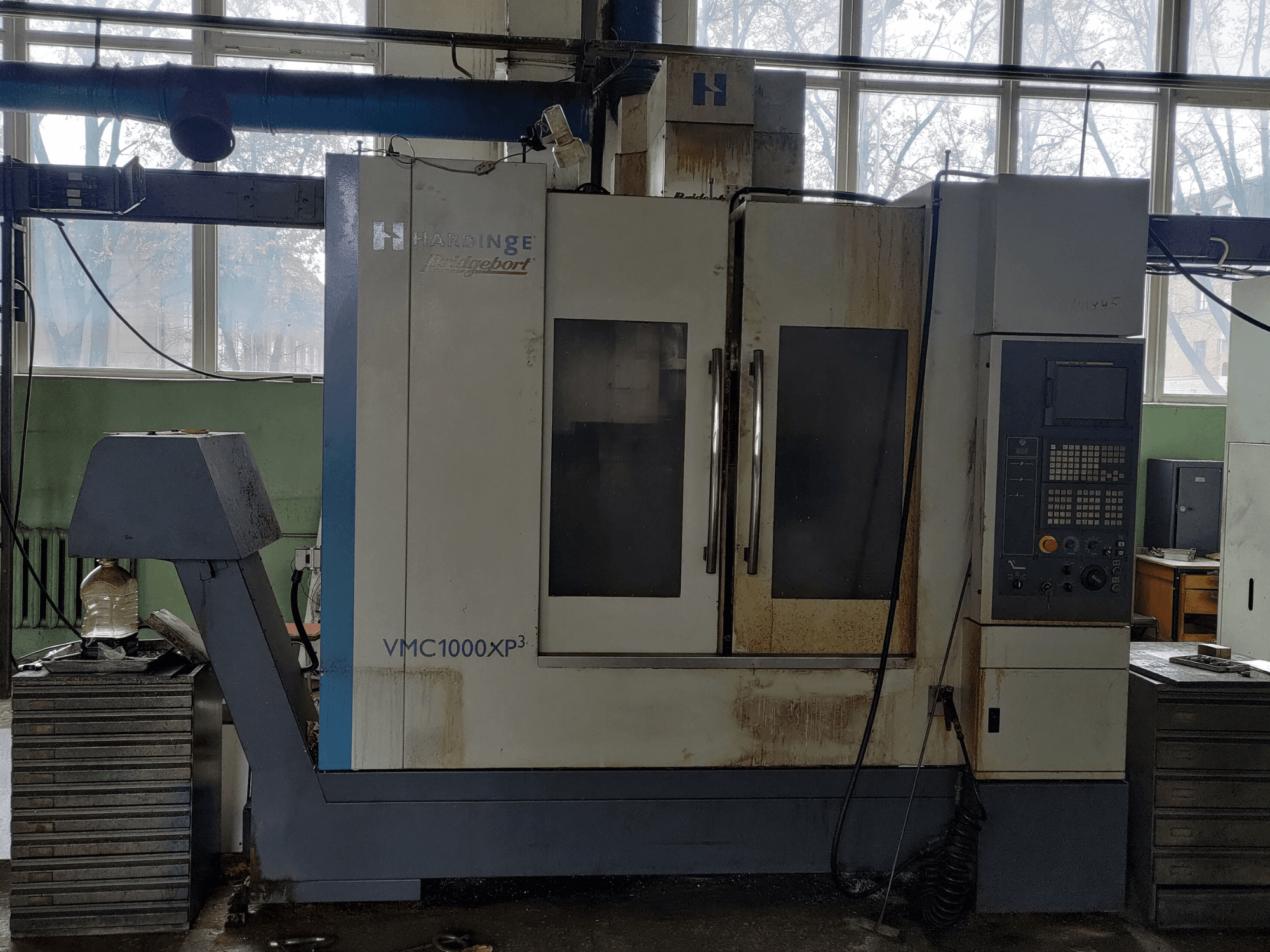 Vertikální obráběcí centrum Bridgeport VMC1000 XP3 v čelním pohledu, na kterém je vidět ovládací panel a mírné opotřebení.