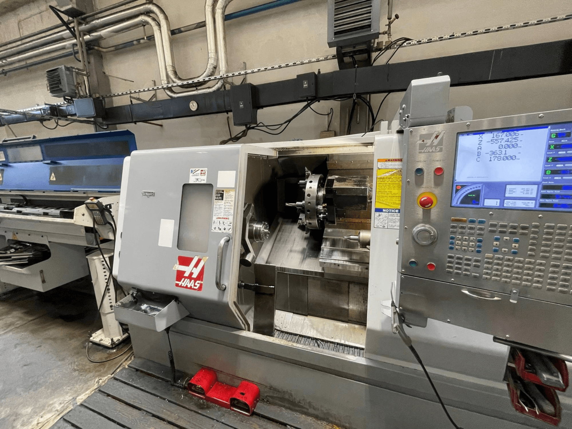 Horizontální soustruh Haas SL-30THE v dílně, vybavený digitálním ovládacím panelem a volně přístupným pracovním prostorem.