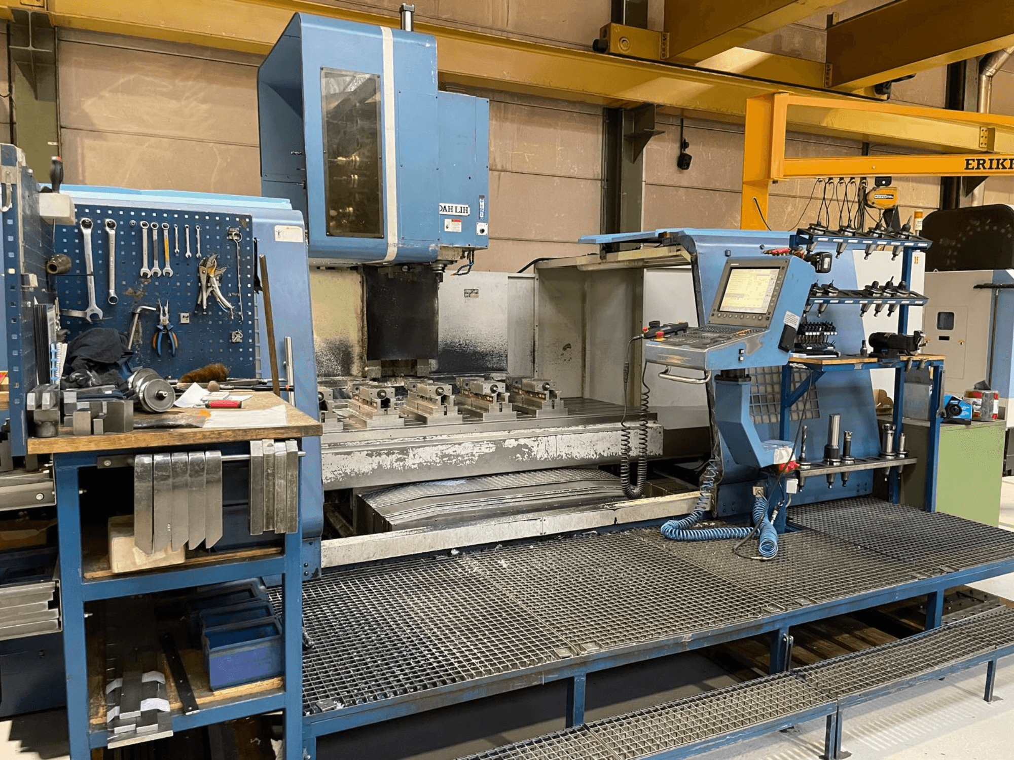 Vertikální obráběcí centrum DAH LIH MCV2600 z čelního pohledu, na kterém je vidět ovládací panel, pracovní stůl a úložný prostor pro nástroje.