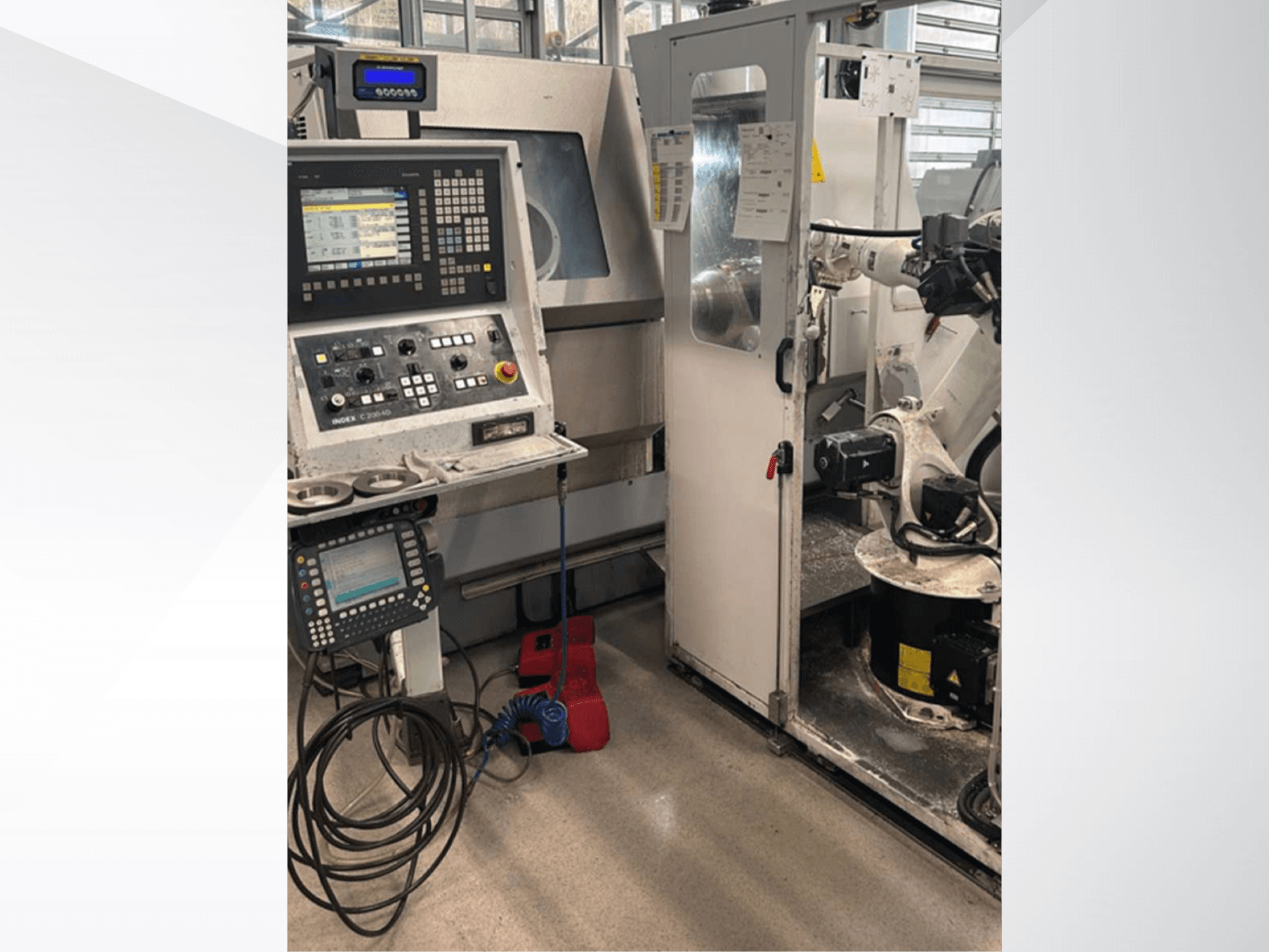 Pohled zepředu na soustružnické centrum Index G 200 RATIO LINE s ovládacím panelem, robotickým ramenem a pracovním prostorem.
