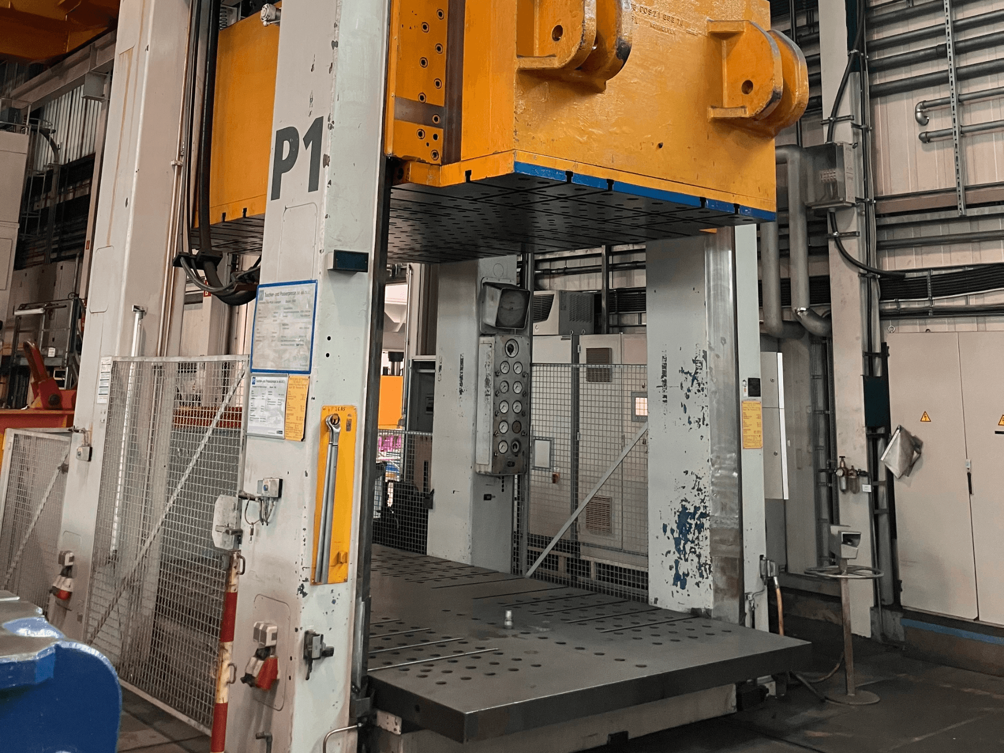 Hydraulický lis FRITZ MULLER ZAE 400-25.1.1, pohled zepředu, na kterém je vidět ovládací panel a velká lisovací plošina v průmyslovém prostředí.