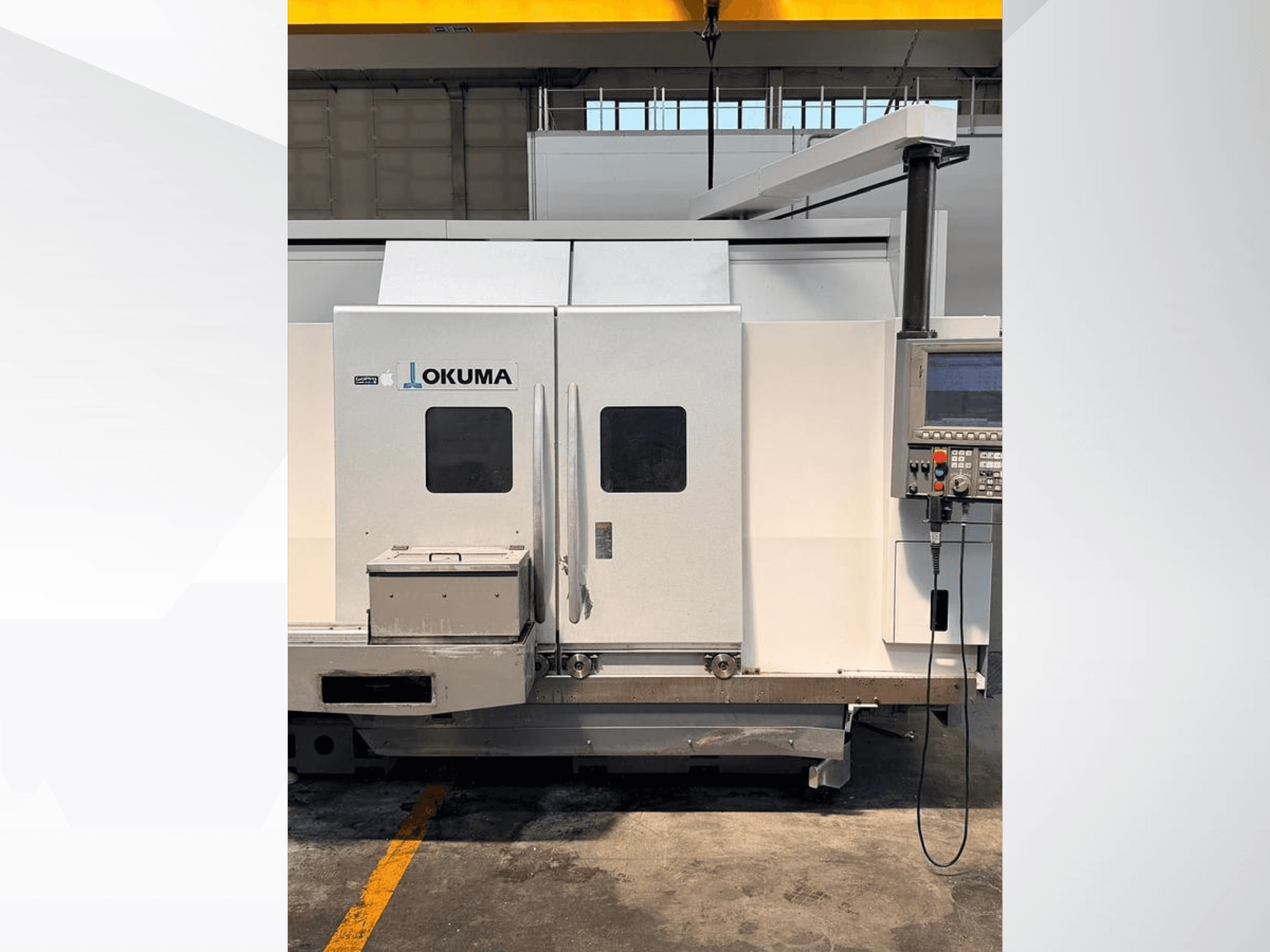 Horizontální soustruh Okuma LB 3000 EX MYW 800, pohled z boku, na kterém je vidět ovládací panel a přístupové dvířka.