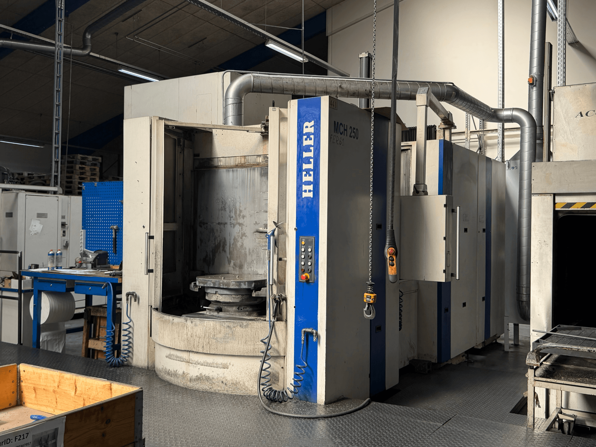 Pohled zepředu na horizontální obráběcí centrum HELLER MCH 250 s ovládacím panelem, velkým otočným stolem a průmyslovým prostředím.