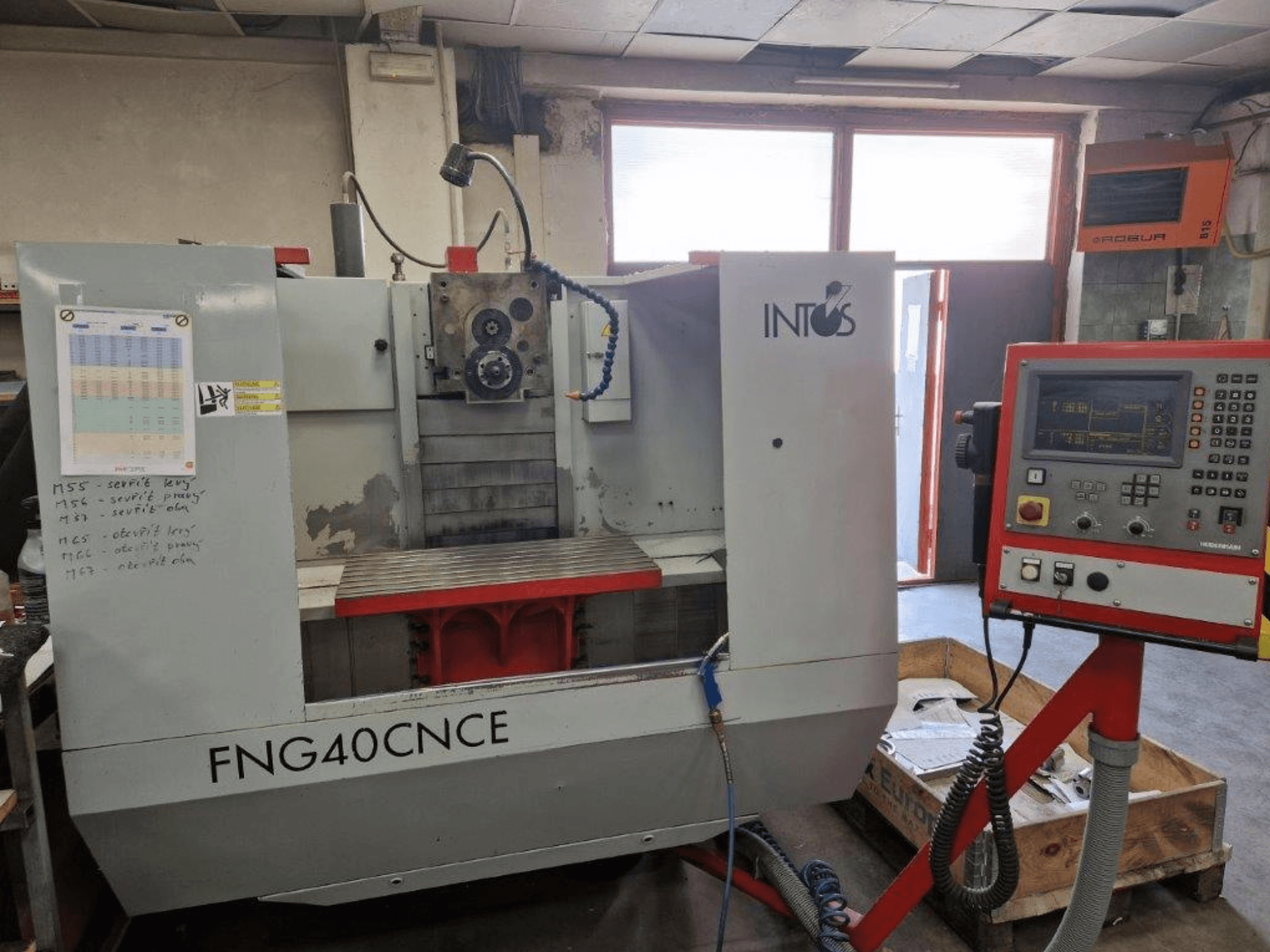 Stroj INTOS FNG40CNC, pohled zepředu, s ovládacím panelem, provozními díly a kovovým pracovním stolem. Ideální pro obrábění.
