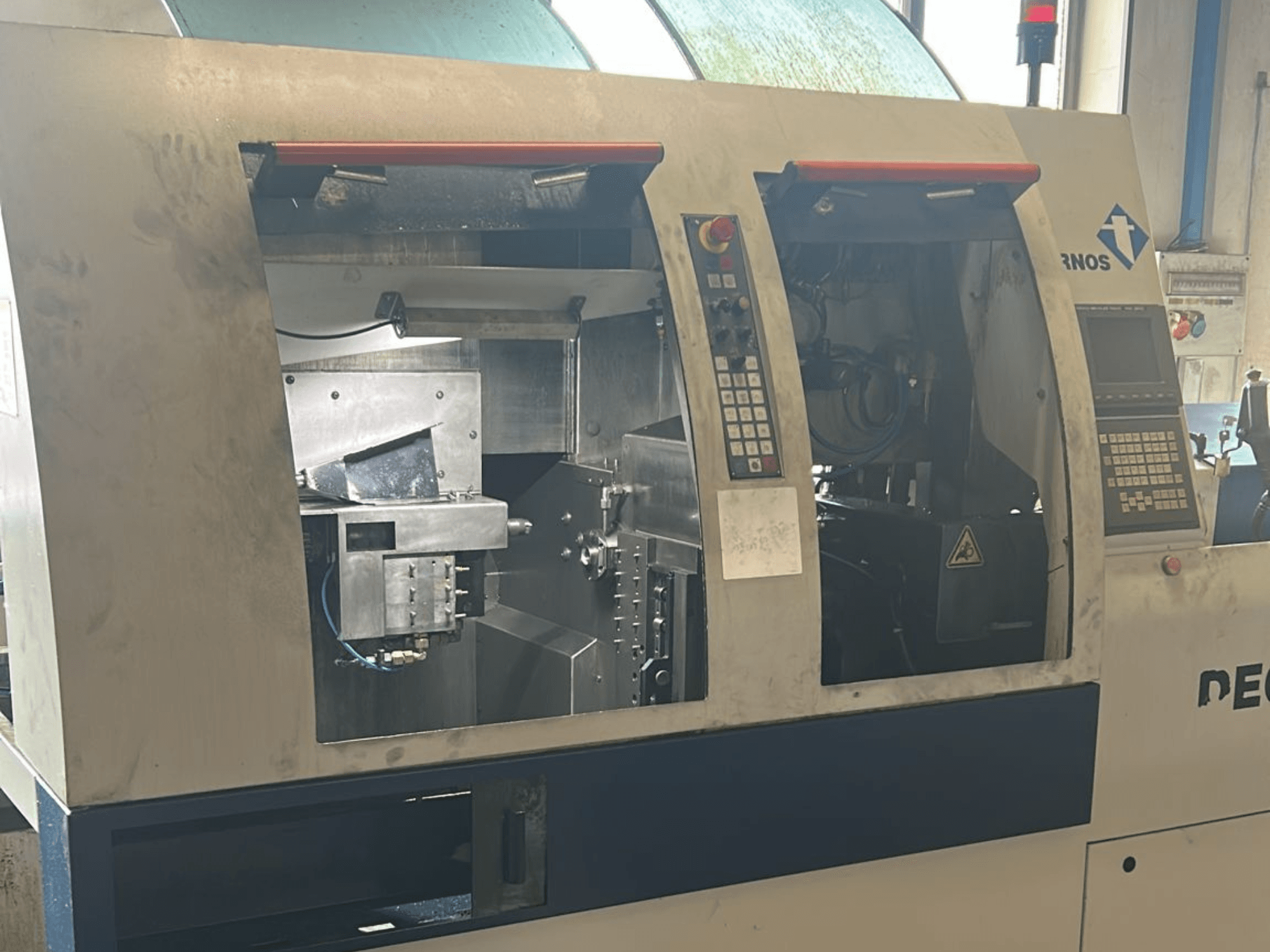 Alt text: b švýcarského typu TORNOS s viditelnými ovládacími panely a vnitřními součástmi.