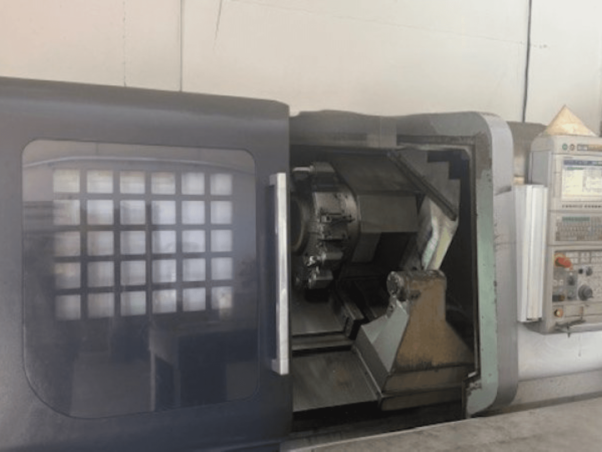 Horizontální soustruh MORI SEIKI NLX 2500M, čelní pohled zobrazující držák nástrojů, ovládací panel a vnitřní mechanismus.