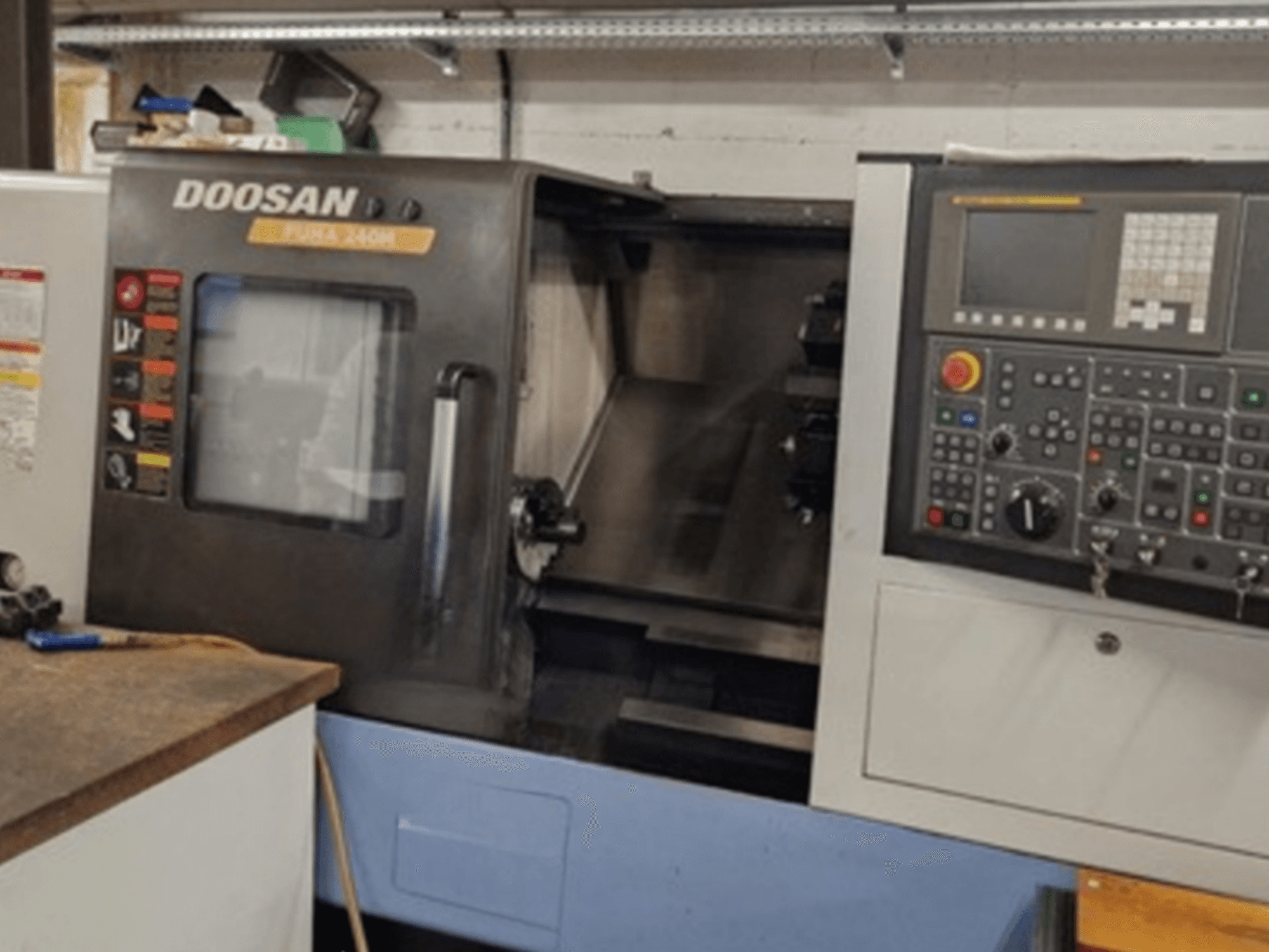 Pohled na horizontální soustruh DOOSAN Puma 240MB zepředu s vyobrazením ovládacího panelu a provozních funkcí.
