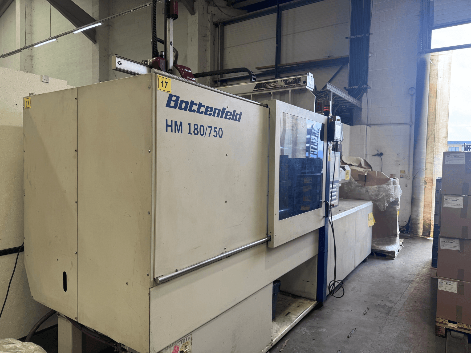 Hydraulický vstřikovací stroj Battenfeld HM150750 při pohledu zepředu, kde je vidět jeho ovládací panel a okolní nastavení.