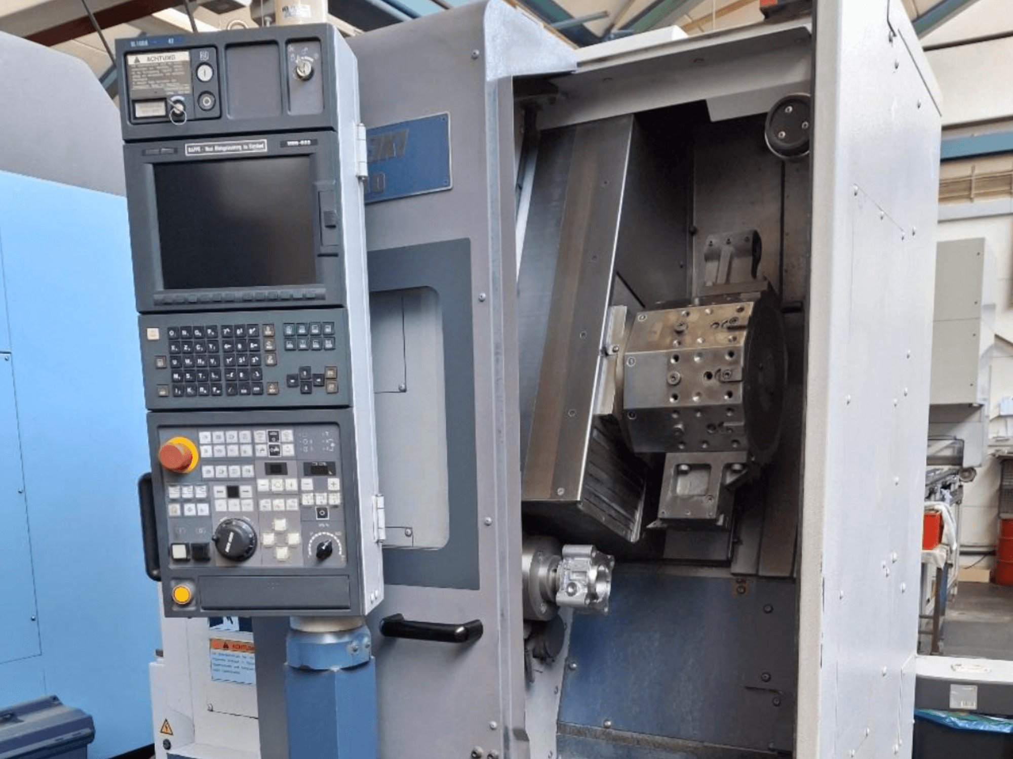 Horizontální soustruh MORI SEIKI SL 1000 z čelního pohledu, s ovládacím panelem a detailním vnitřním mechanismem.