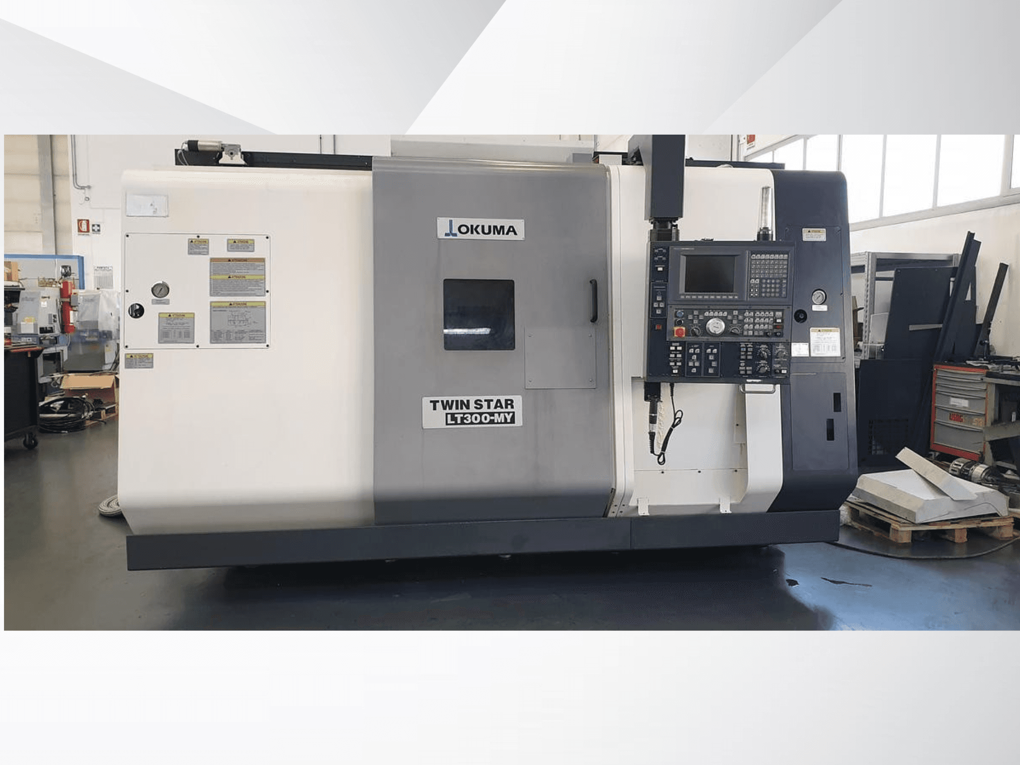 CNC soustruh Okuma Twin Star LT300-MY, čelní pohled s viditelným ovládacím panelem a provozními štítky.