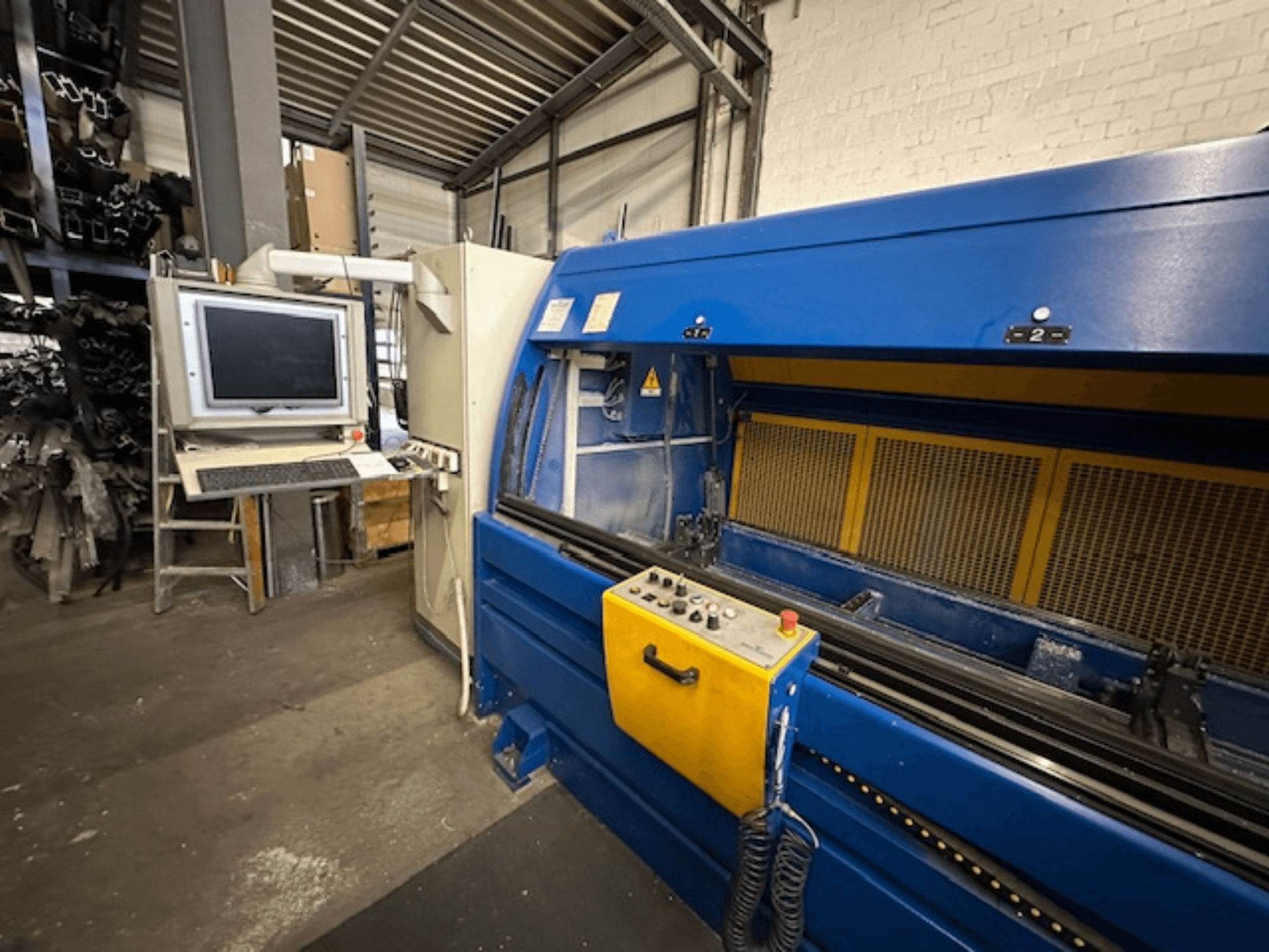 Pohled zepředu na univerzální obráběcí centrum SCHÜCO Profilbearbeitungscenter 299 650 s řídicími prvky a počítačovým pracovištěm.