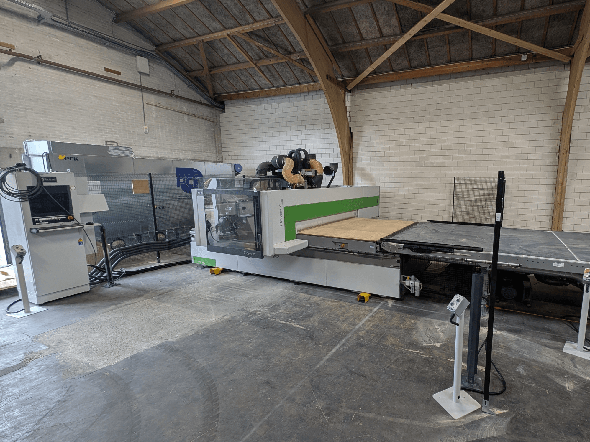 Obráběcí centrum PCK CNC, pohled zepředu, s velkým řezným ložem, ovládacím panelem, systémem odsávání prachu a robustní konstrukcí.