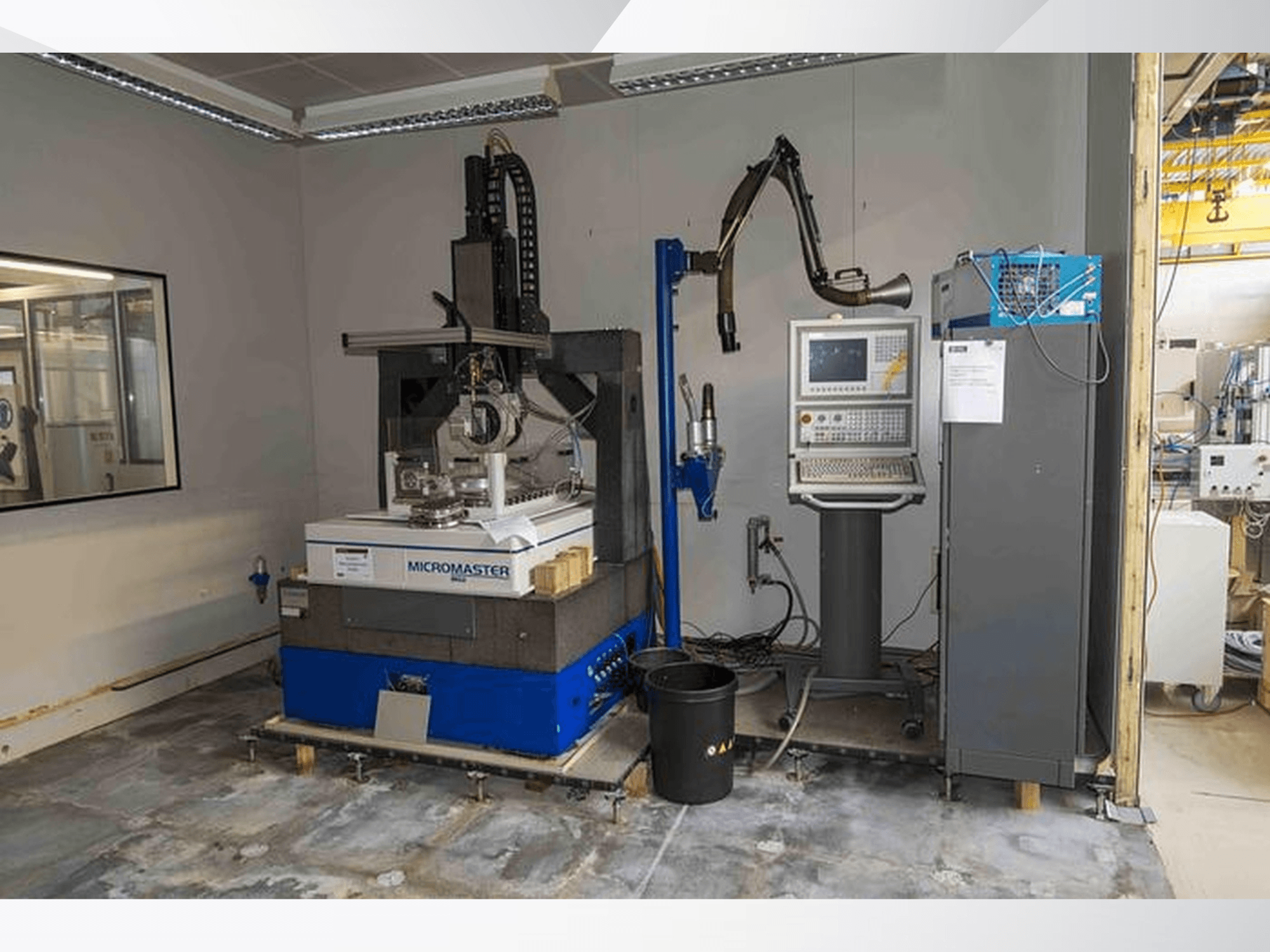 Plošná bruska KUGLER Micromaster MG2 v dílně, pohled zepředu s ovládacím panelem a robotickým ramenem v blízkosti.
