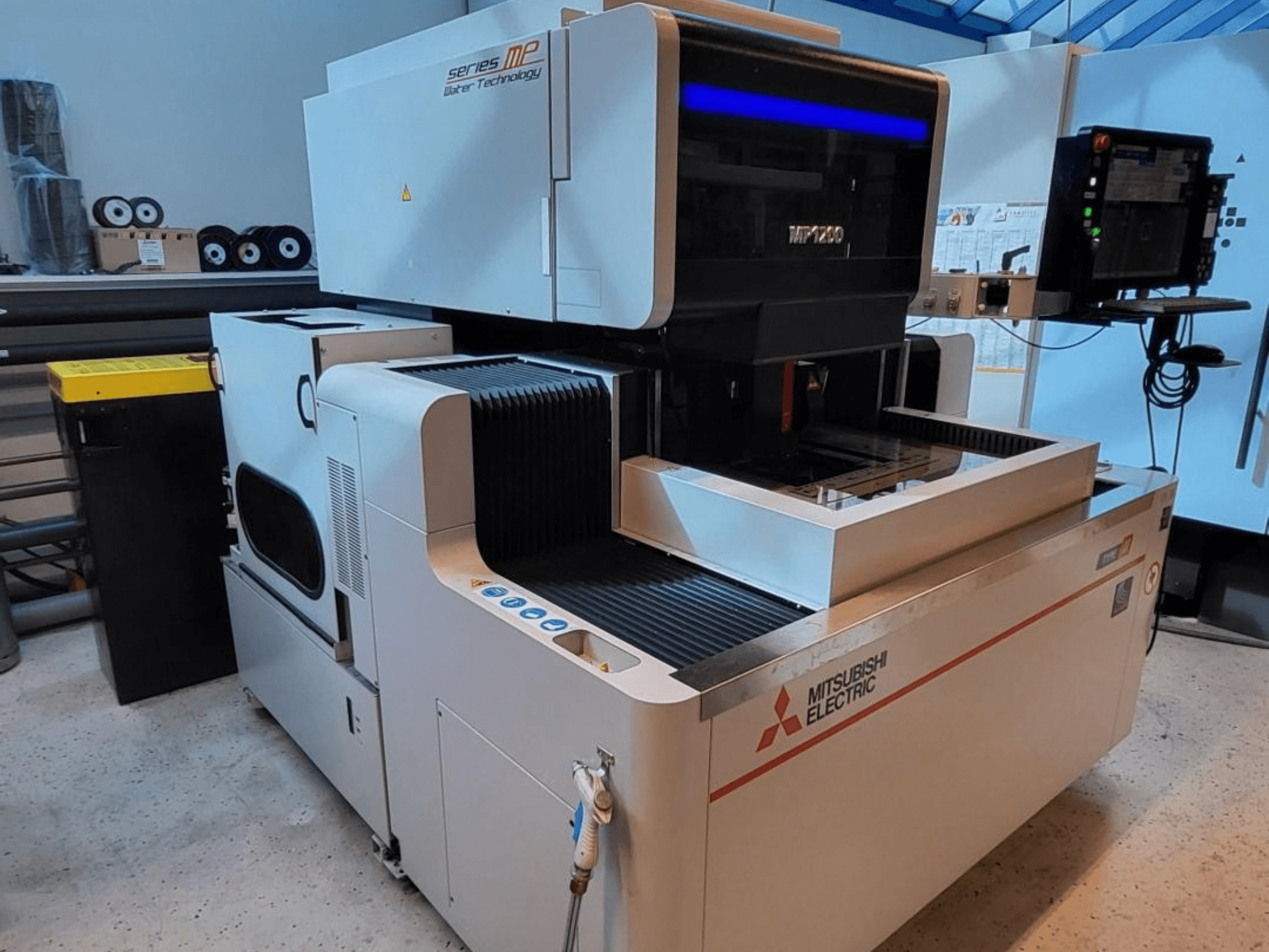 Elektroerozivní stroj Mitsubishi MP1200, pohled zepředu, s ovládacím panelem, špičkovými technologickými prvky a elegantním designem.
