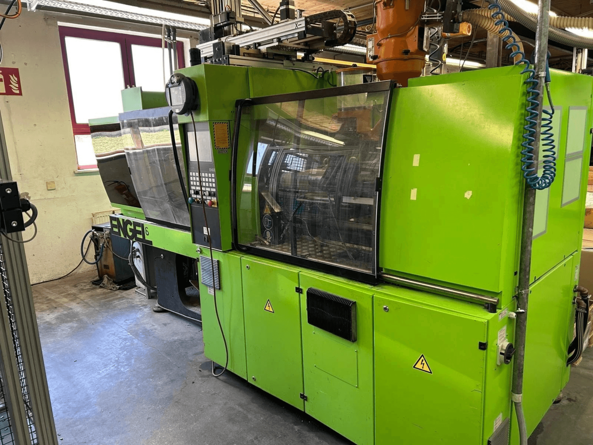 Pohled zepředu na hydraulický vstřikovací lis Engel VICTORY 330/80 Tech, na kterém je vidět zelený exteriér a ovládací panel.