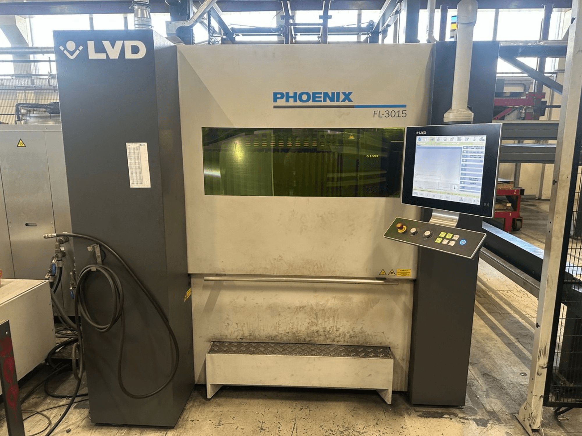 Laserový řezací stroj LVD Phoenix FL-3015, pohled zepředu, s digitálním ovládacím panelem a viditelnými trubkami.