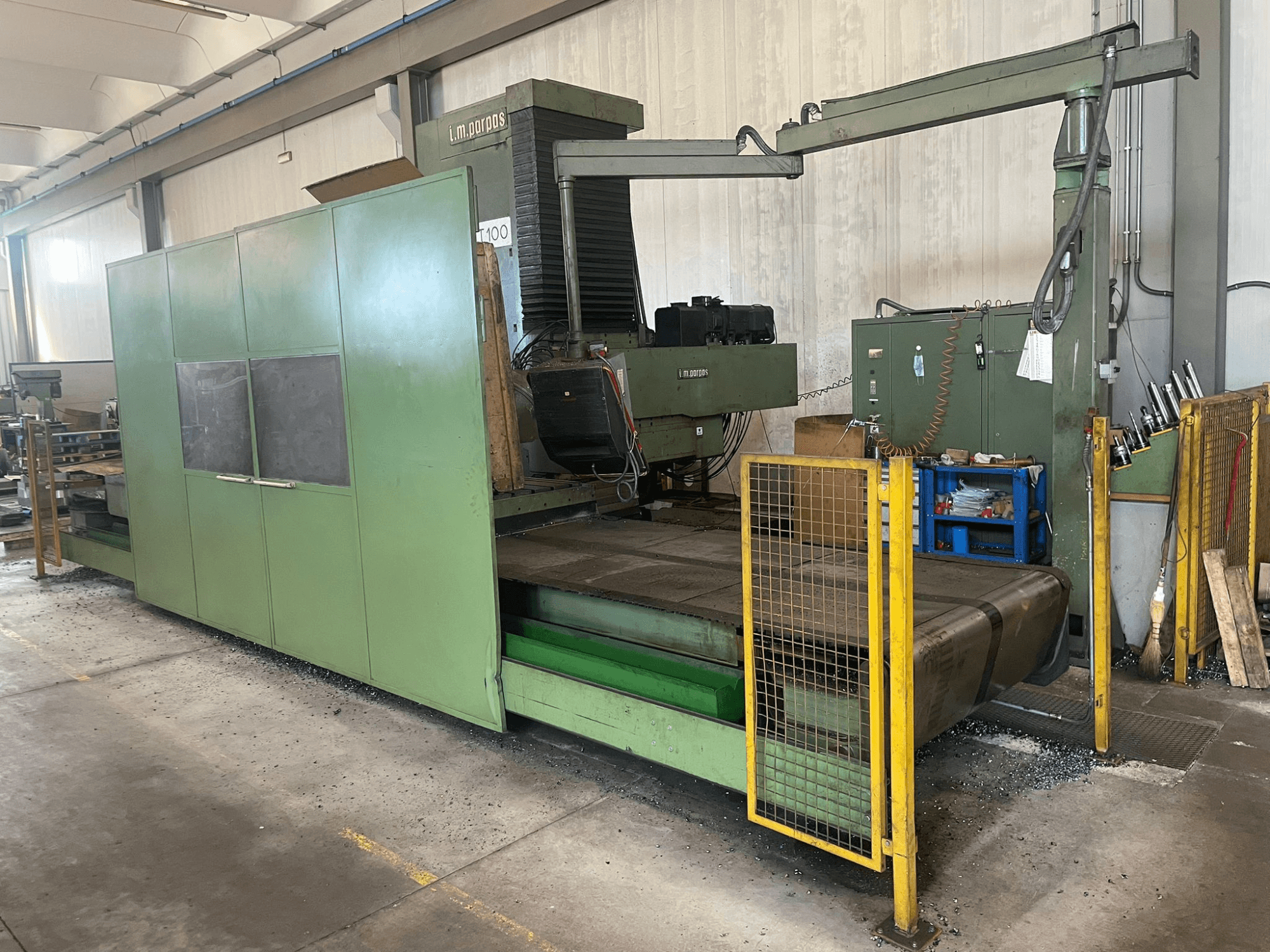 Velká zelená průmyslová frézka s bezpečnostními zábranami, pohled zepředu, se štítkem modelu "l.m. parpas" a viditelnými ovládacími prvky.