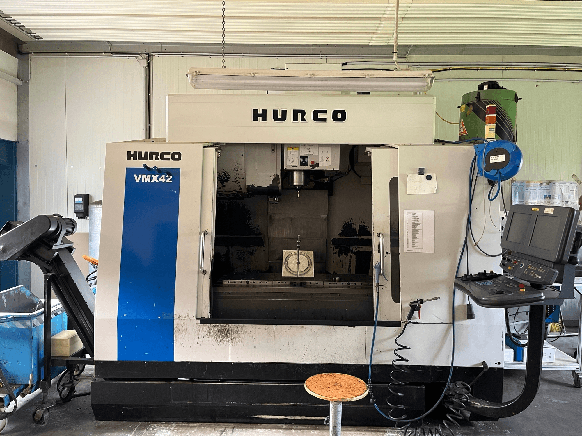 Vertikální obráběcí centrum Hurco VMX 42 v bočním pohledu, zobrazující ovládací panel, vřeteno a nastavení obrobku.