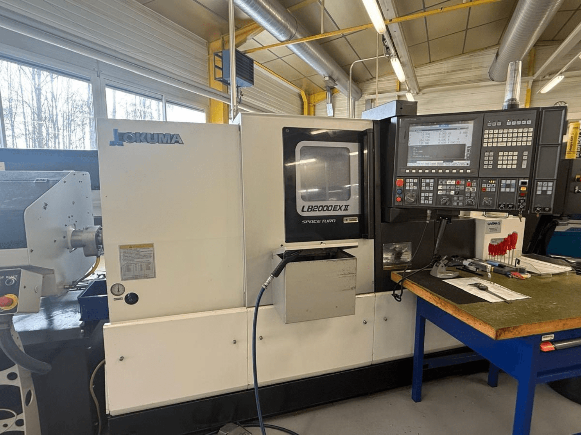 Horizontální soustruh Okuma LB2000EX II, pohled zepředu; ovládací panel, prostor vřetena a okolní pracovní prostor.