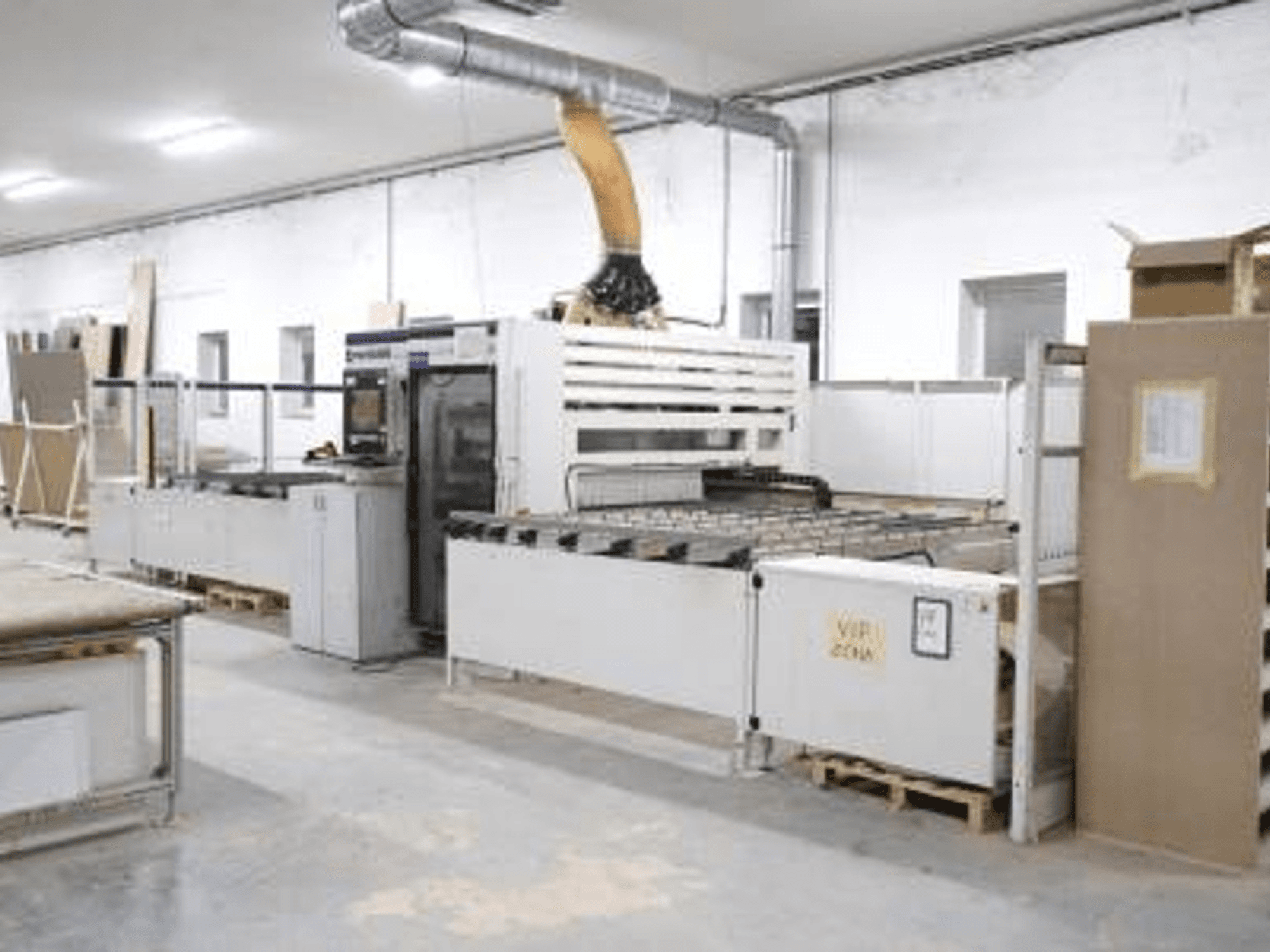 CNC obráběcí centrum na dřevo SCM Morbidelli UNIFLEX HP v dílně, pohled zepředu, kde je vidět jeho ovládací panel a podávací systém.