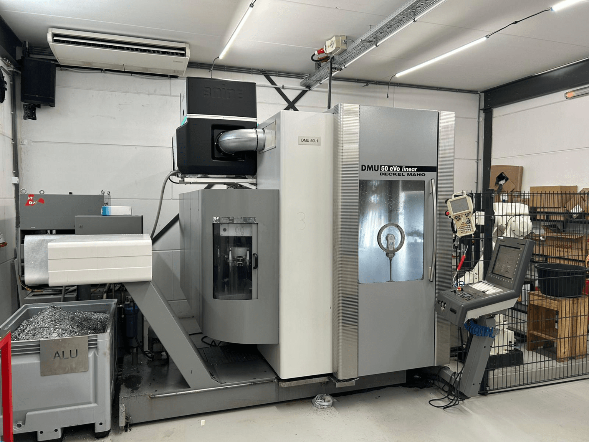 Lineární frézka DMU 50 eVo od společnosti Deckel Maho, pohled zepředu, s ovládacím panelem a zásobníkem na hobliny.