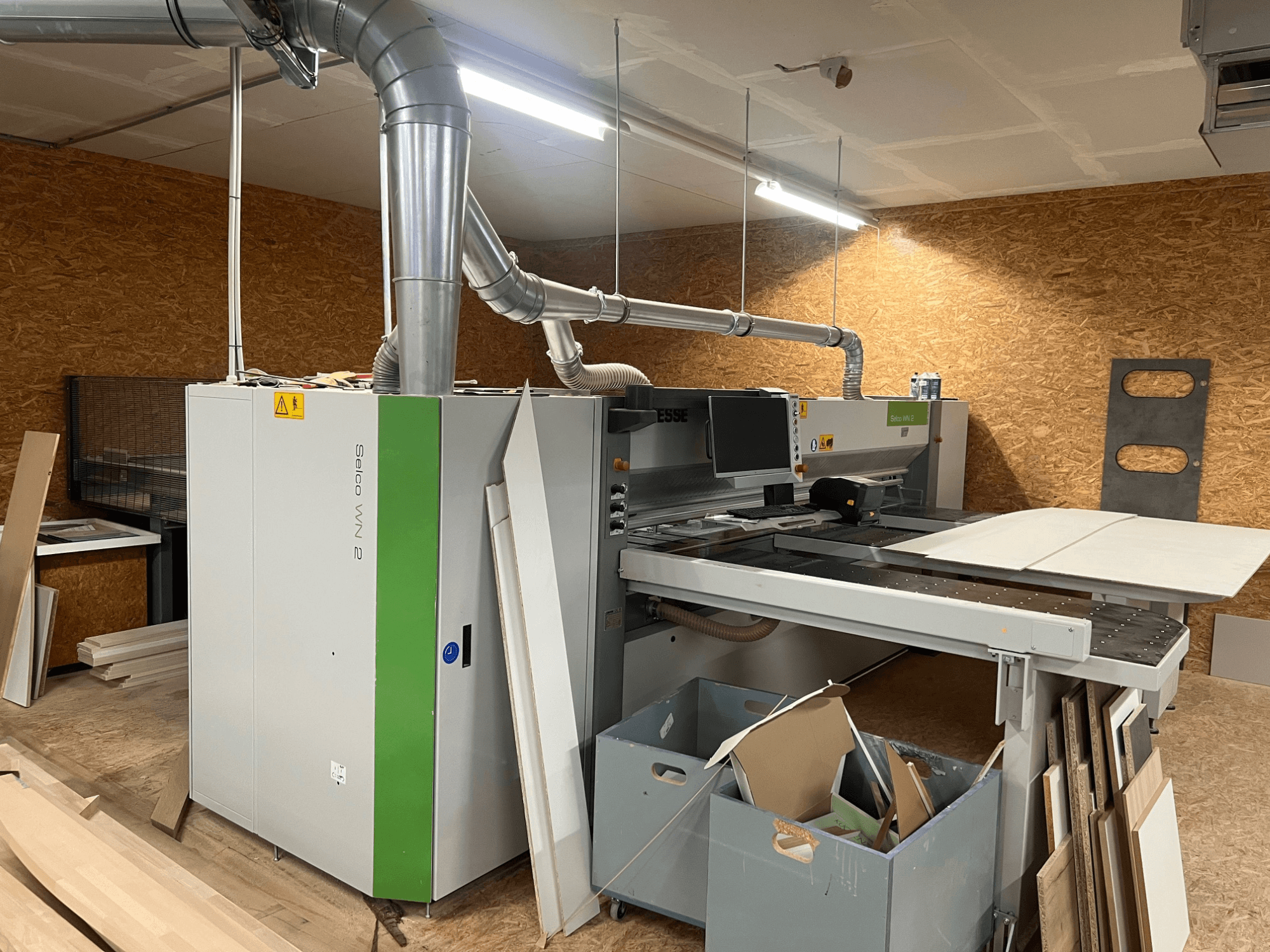 Desková pila BIESSE Selco WN 2 v dílně, s velkým řezacím stolem a systémem odsávání prachu, boční pohled.