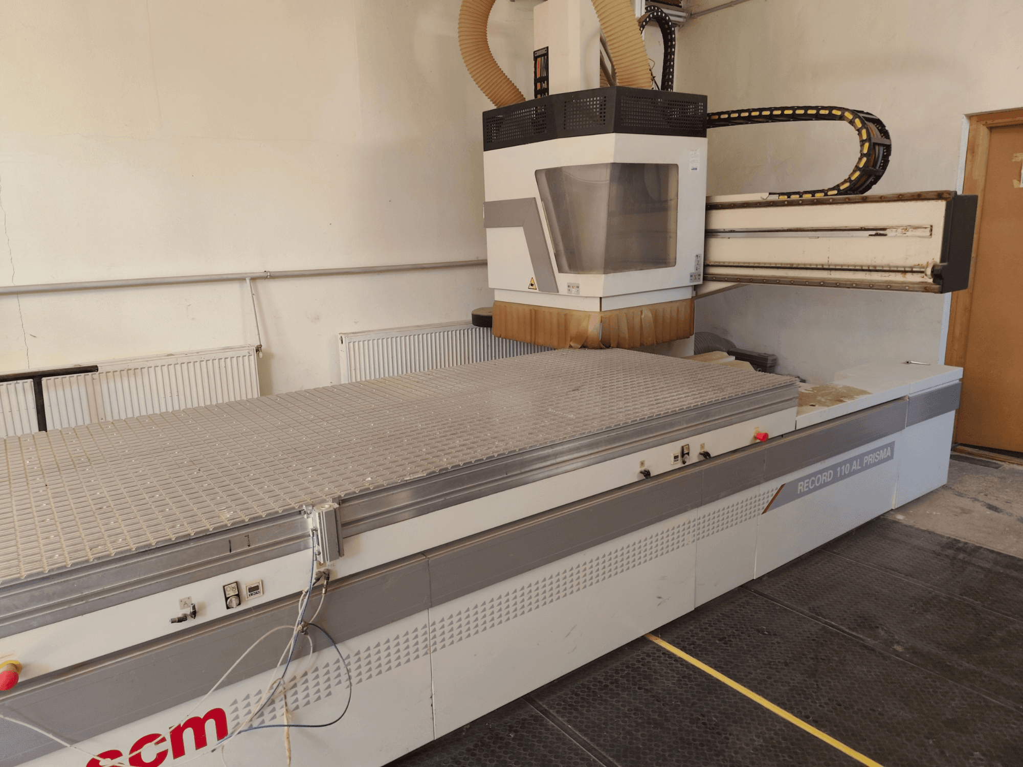 CNC obráběcí centrum na dřevo SCM Record 110AL, boční pohled znázorňující velký pracovní stůl a frézovací hlavu.
