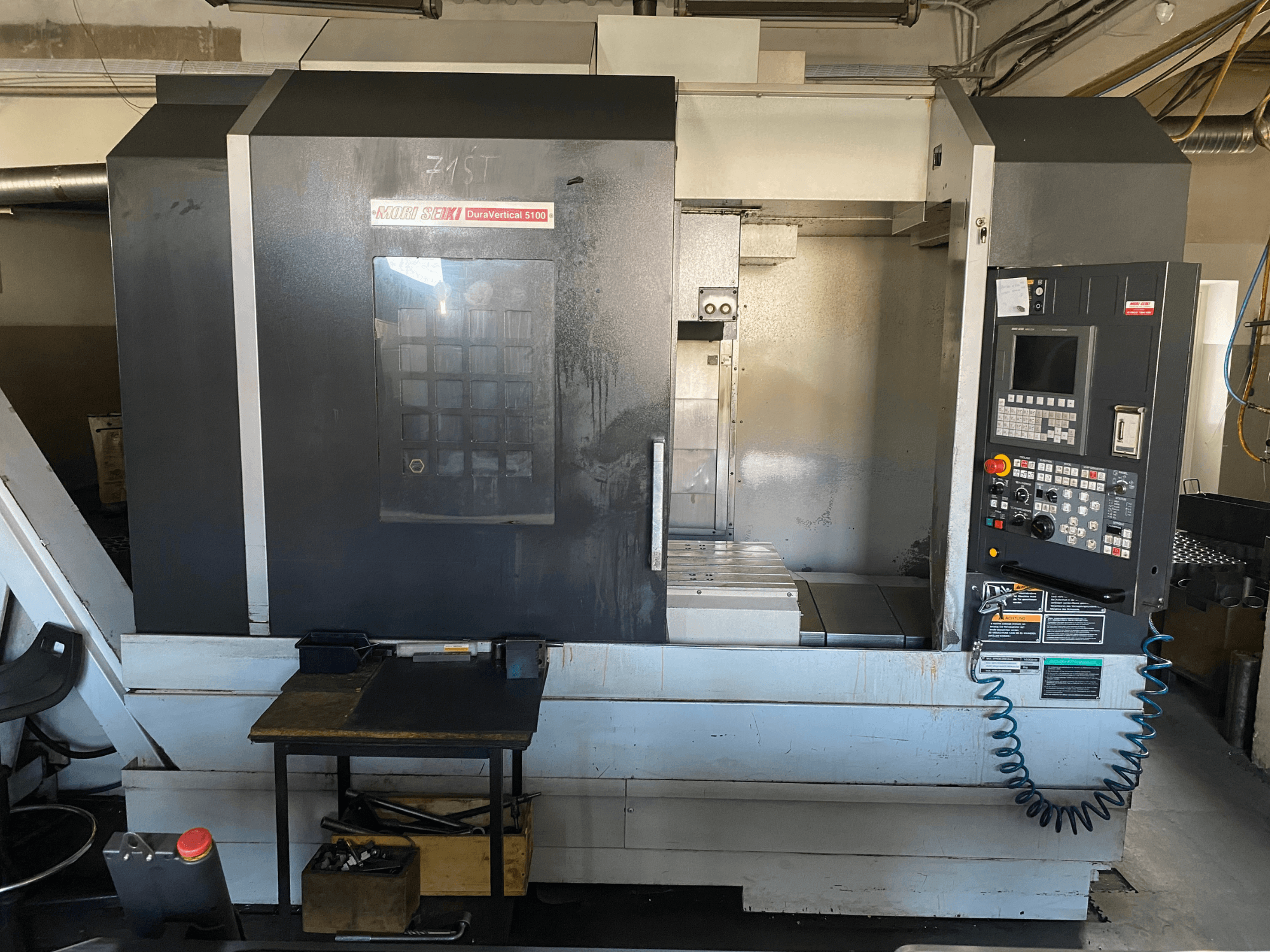 Stroj MORI SEIKI DuraVertical 5100 z čelního pohledu, na kterém je vidět ovládací panel, pracovní prostor a detaily stroje.