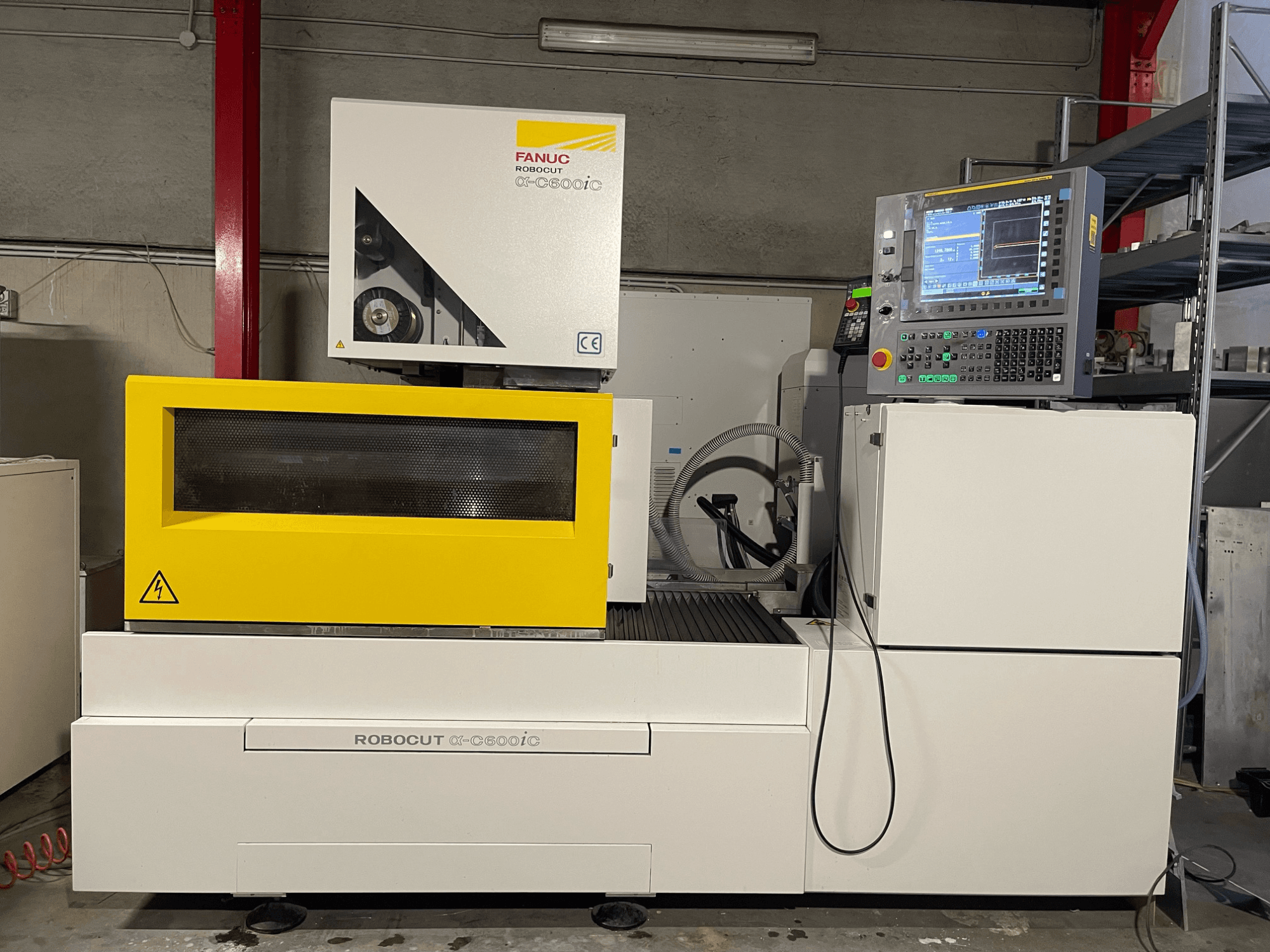 FANUC Robocut α-C600iC, boční pohled na CNC stroj se žlutým bezpečnostním krytem a ovládacím panelem, který ukazuje schopnost přesného řezání.