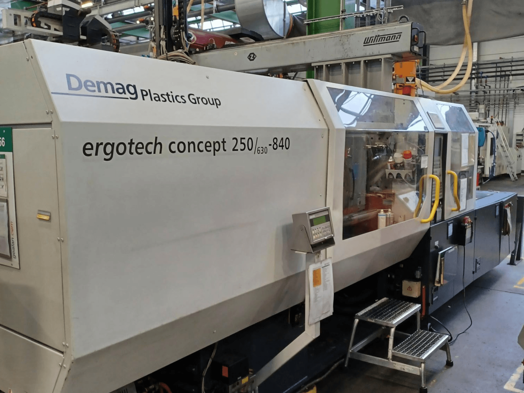 Vstřikovací stroj Demag ergotech concept 250/630-840, pohled zepředu, s digitálními ovládacími prvky a průhlednými bezpečnostními kryty.