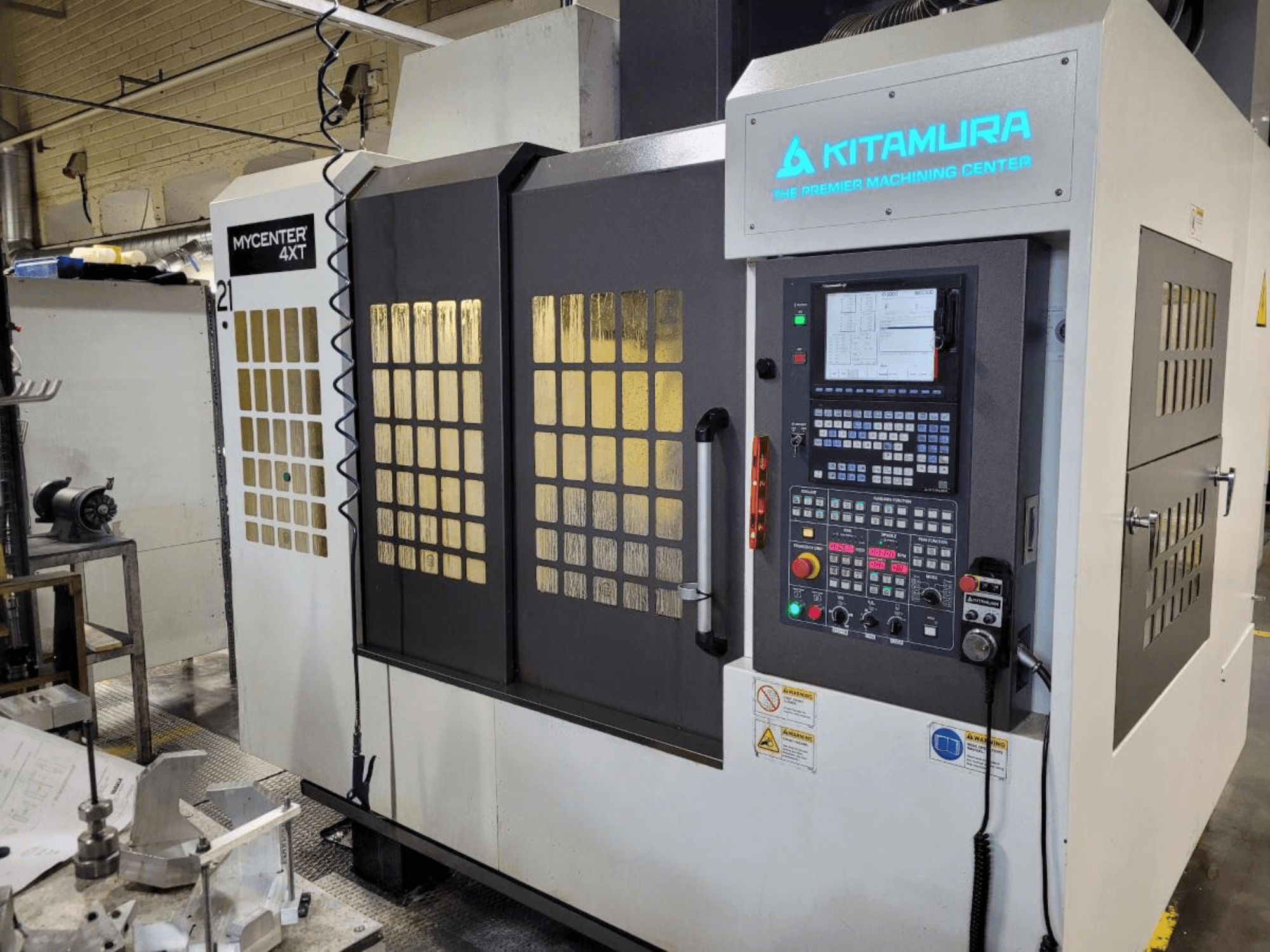 Vertikální pohled na obráběcí centrum Kitamura Mycenter-4XT s ovládacím panelem a osvětleným označením.