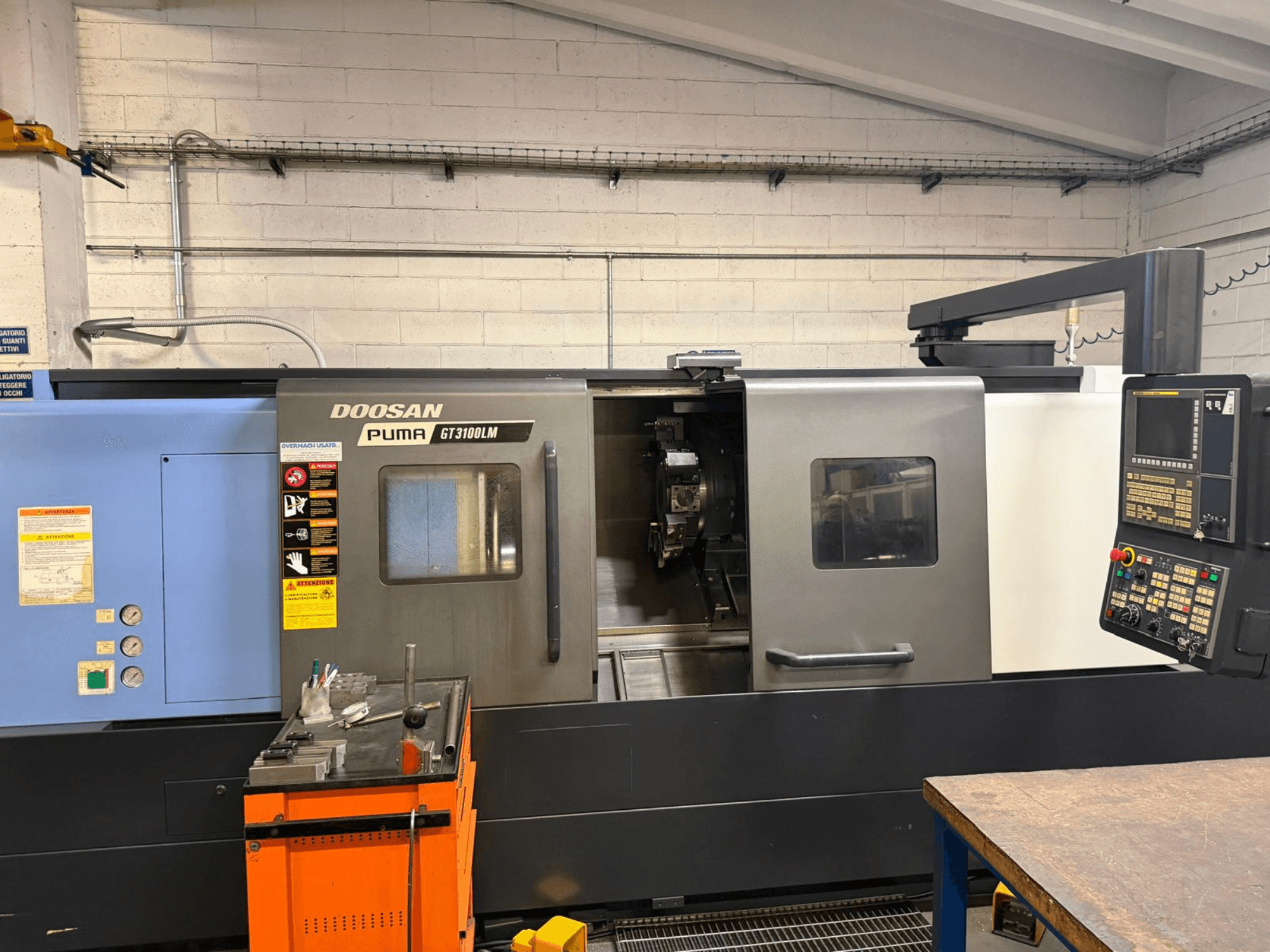 Pohled na horizontální soustruh DOOSAN PUMA GT3100LM zepředu, ovládací panel a pracovní plocha s nástroji.