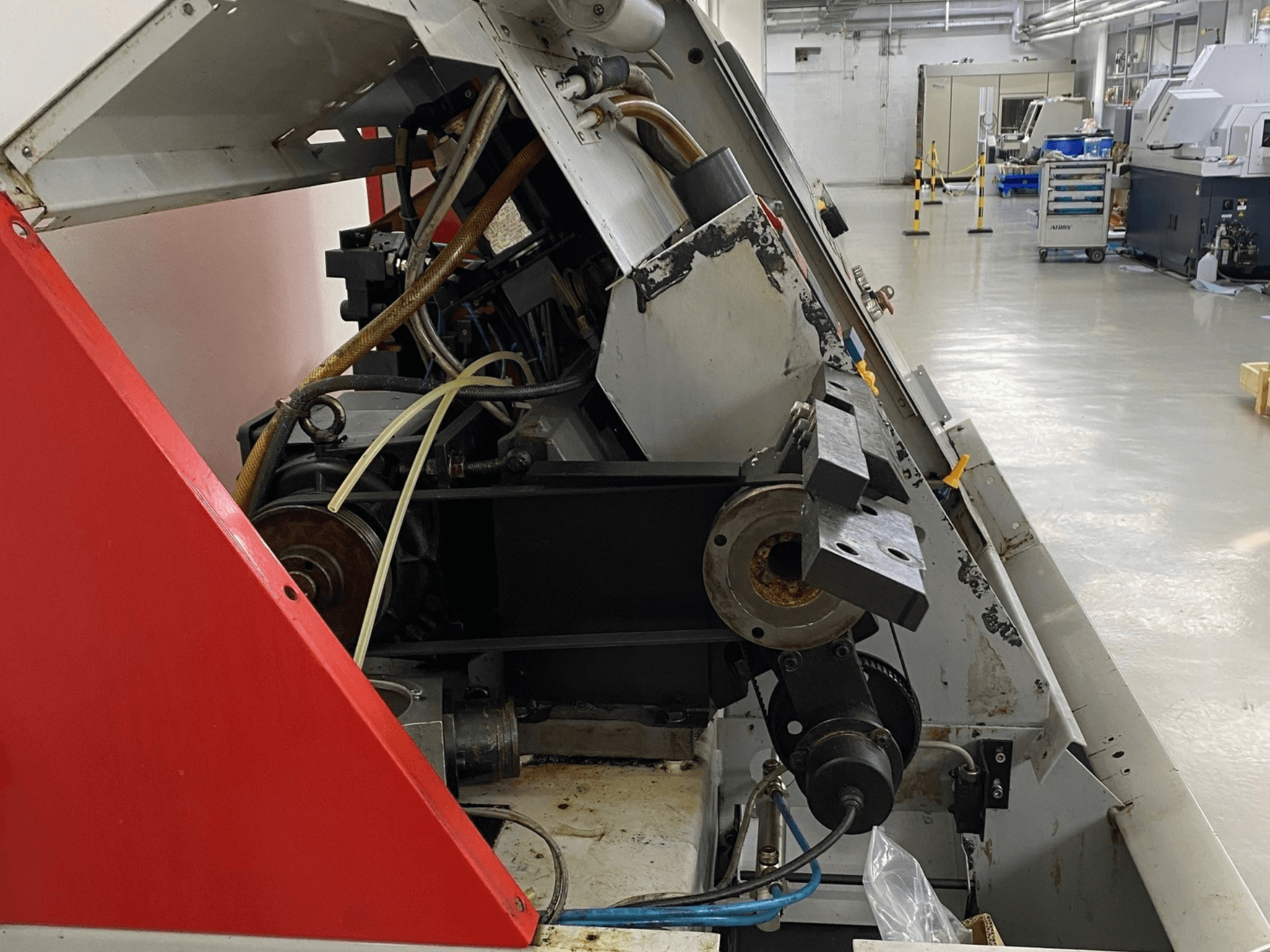 Horizontální soustruh EMCO Emcoturn 325, boční pohled na komponenty pohonu a hydrauliku v průmyslovém prostředí.